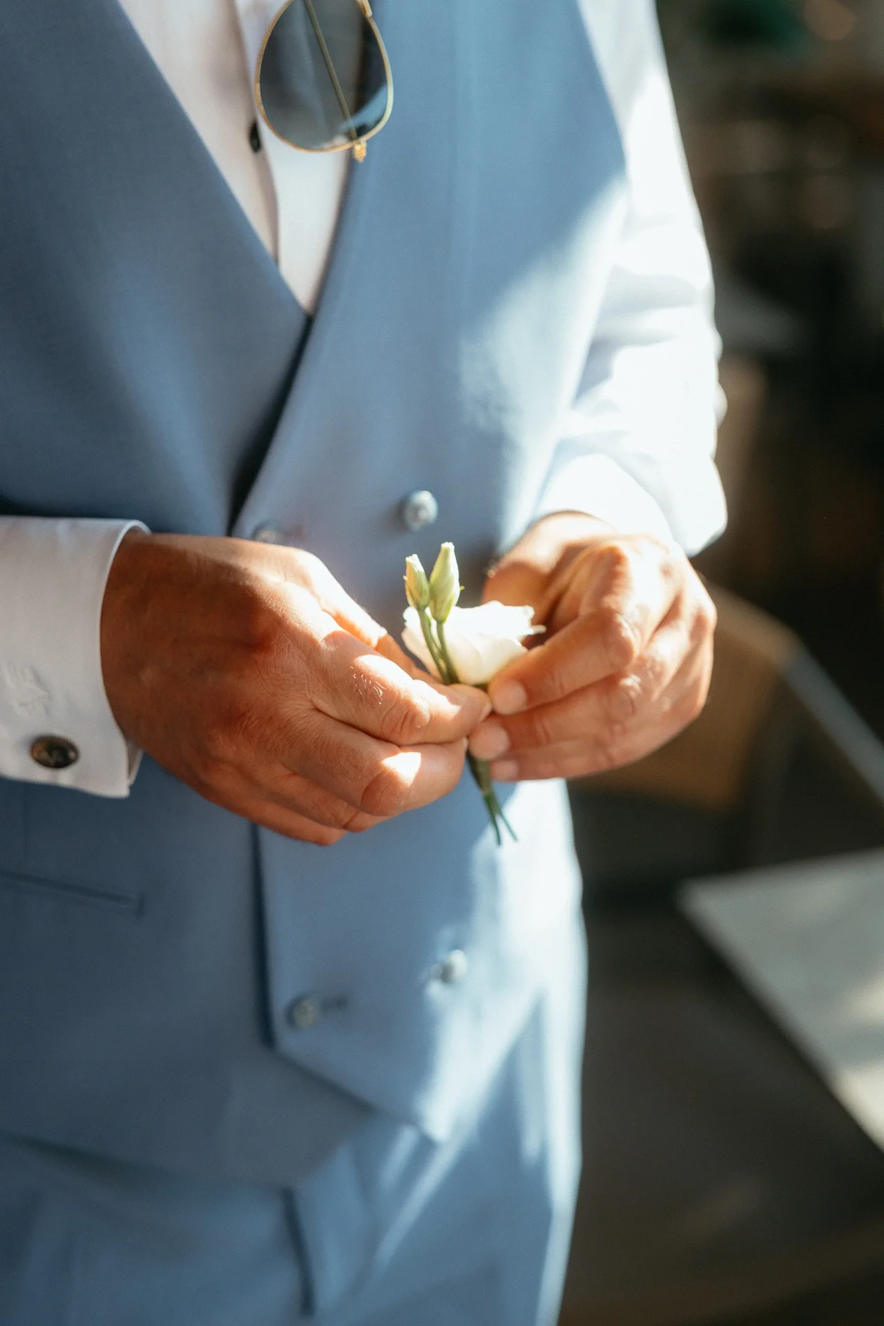 groom-holding-his-buttonhole.webp