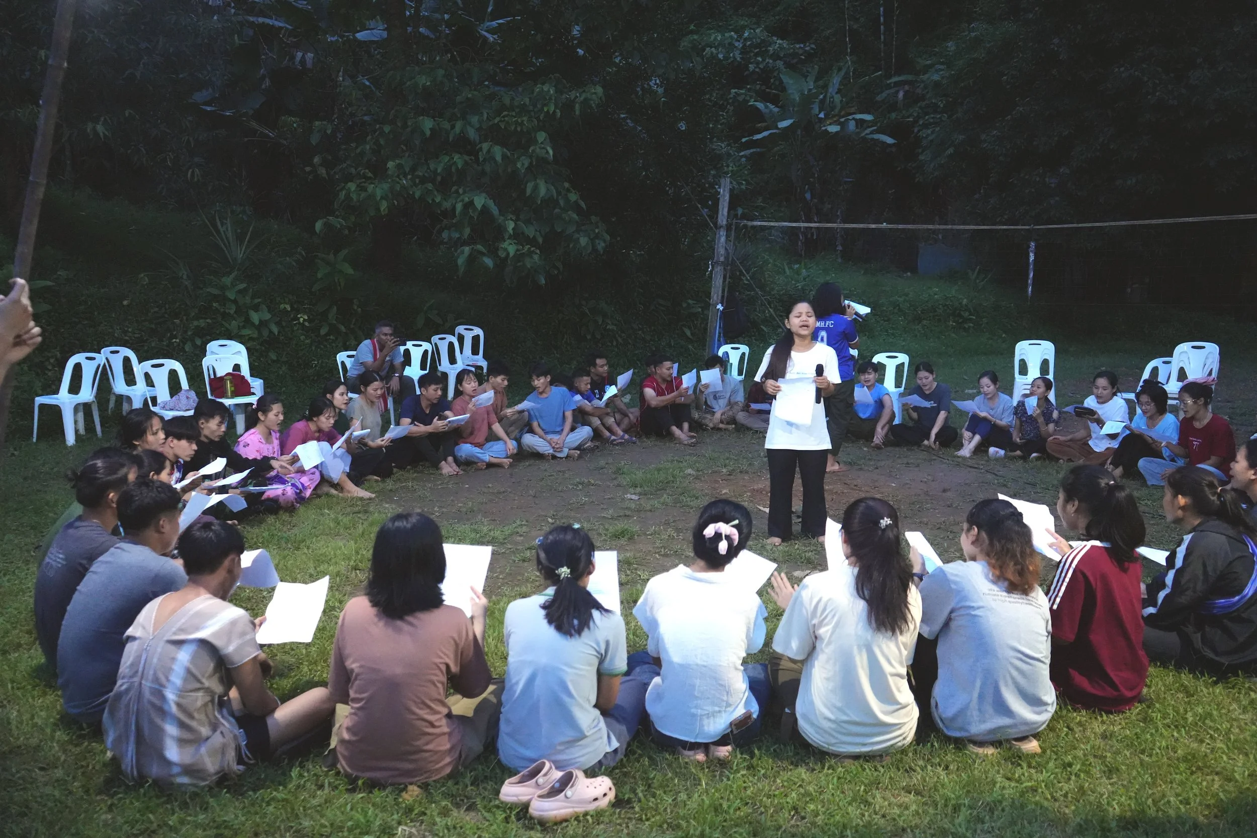 Bway leads students in a prayer and worship meeting.