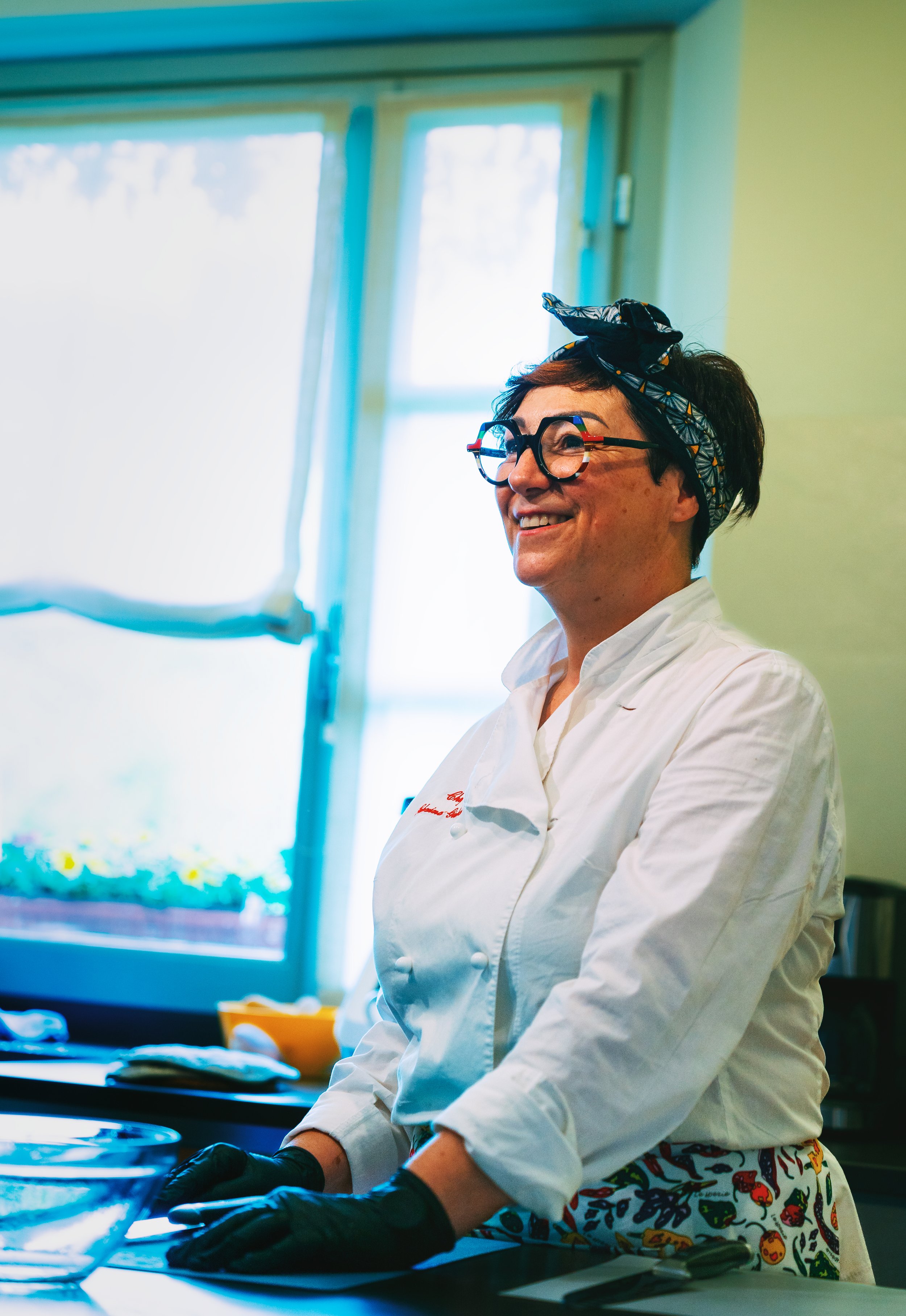 Smiling chef with headband and glasses in a kitchen