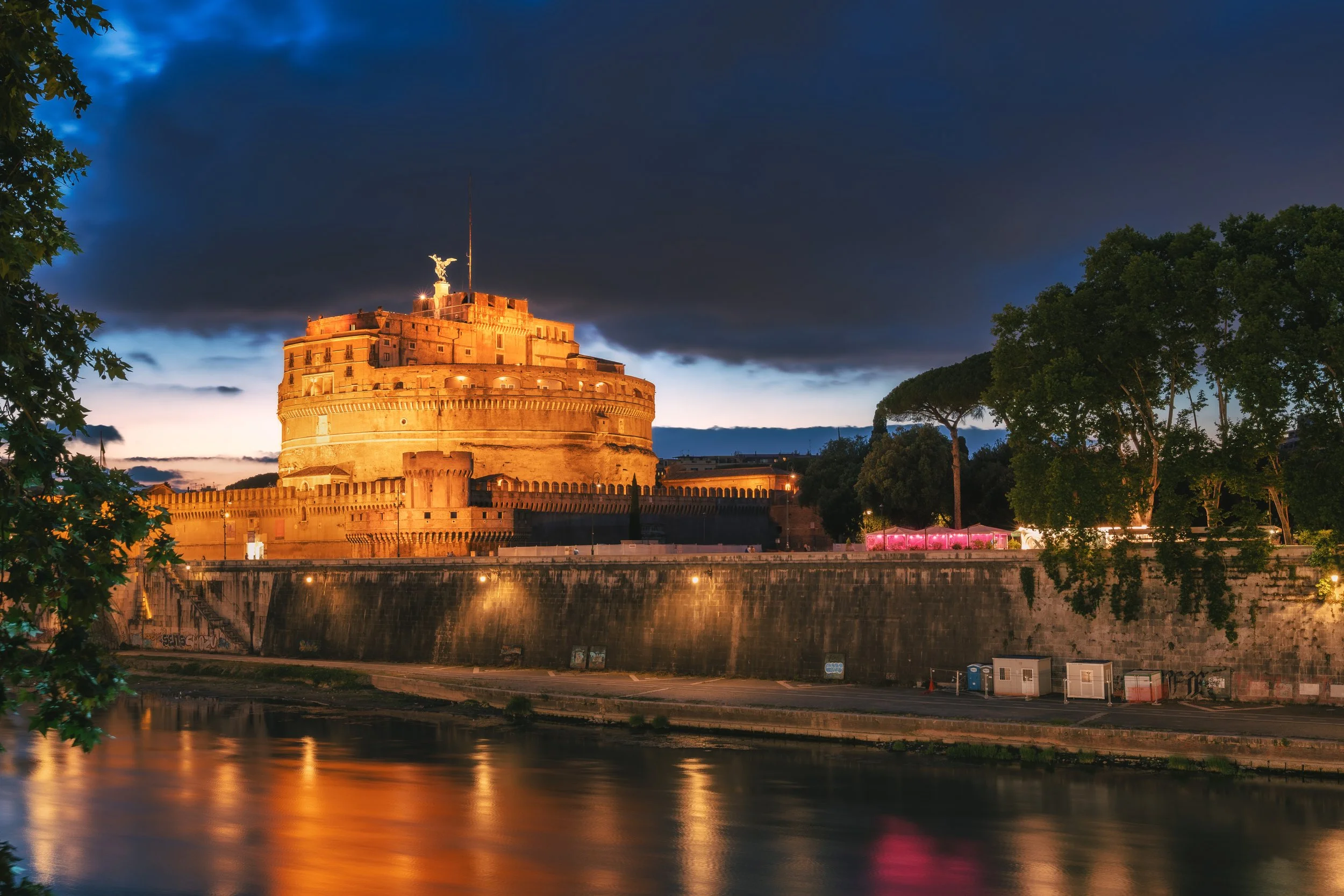 Castel Sant'Angelo illuminated at night with its reflection in the Tiber River, Rome, Italy.