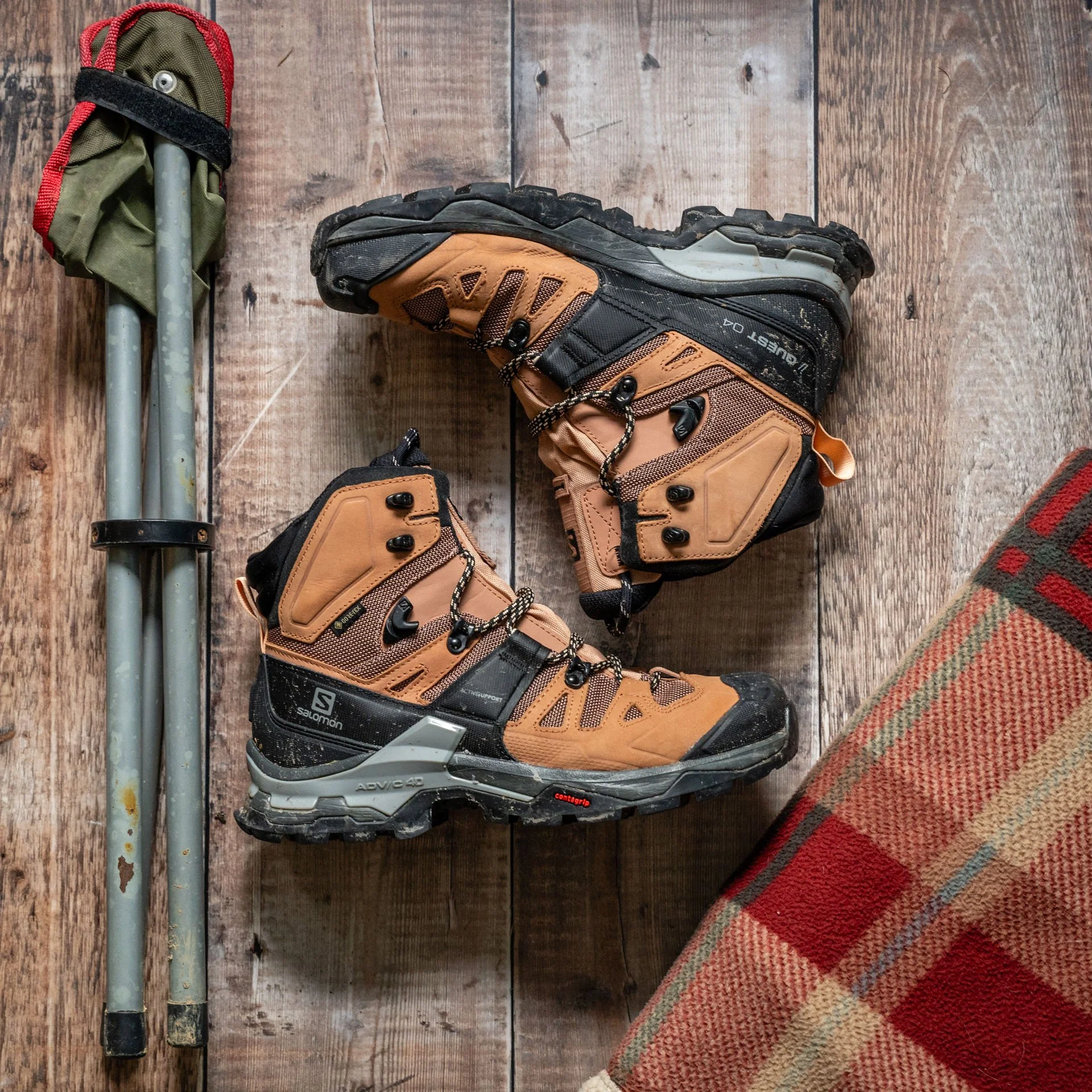 camping stool, walking boots and a blanket on a wooden floor