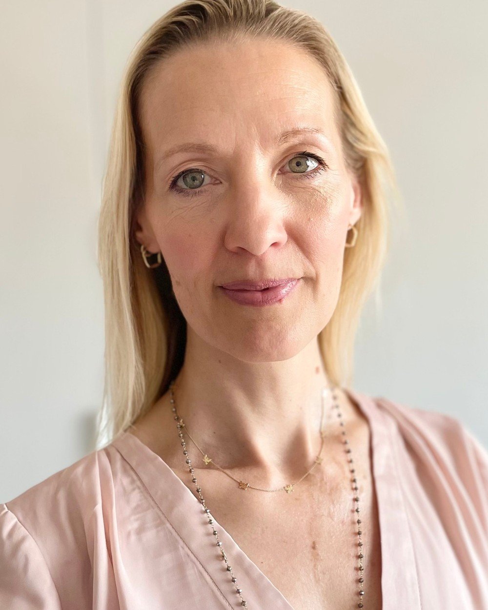 Isabelle, founder of The School of Somatic Leadership for Women, smiling warmly in a softly lit portrait