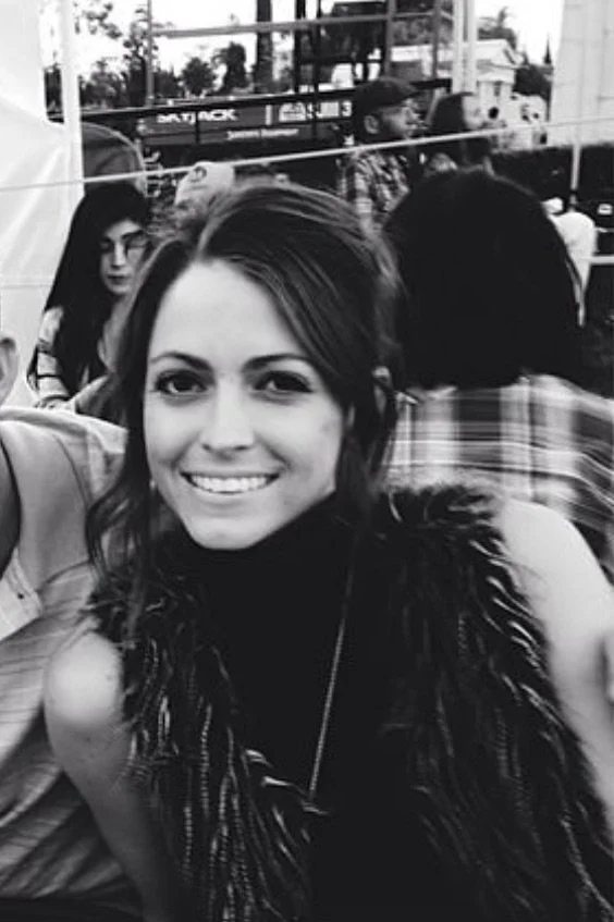 Smiling woman with people in background, black and white photo.