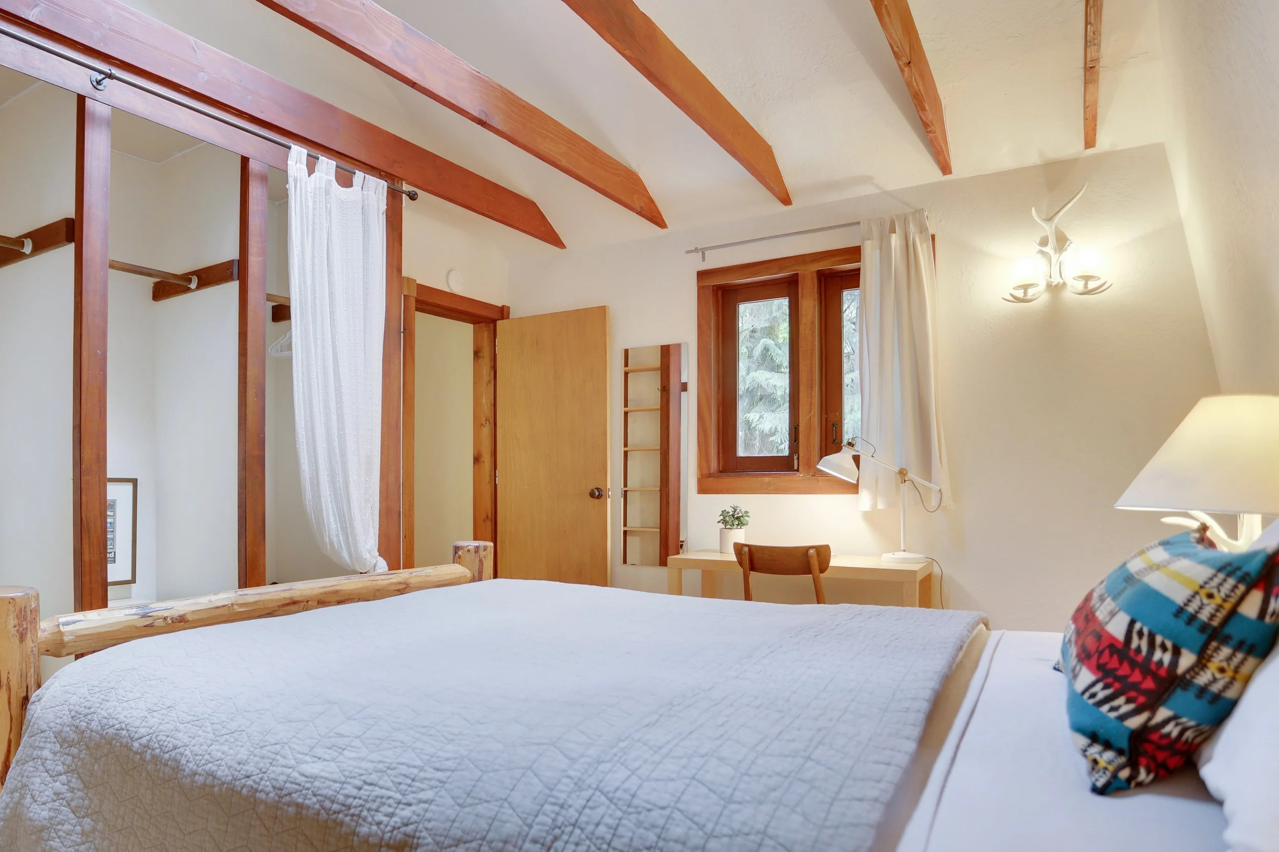 Exposed beams and wood trim carry the chalet feel into the bedroom and remind you of the unique setting you're staying in.