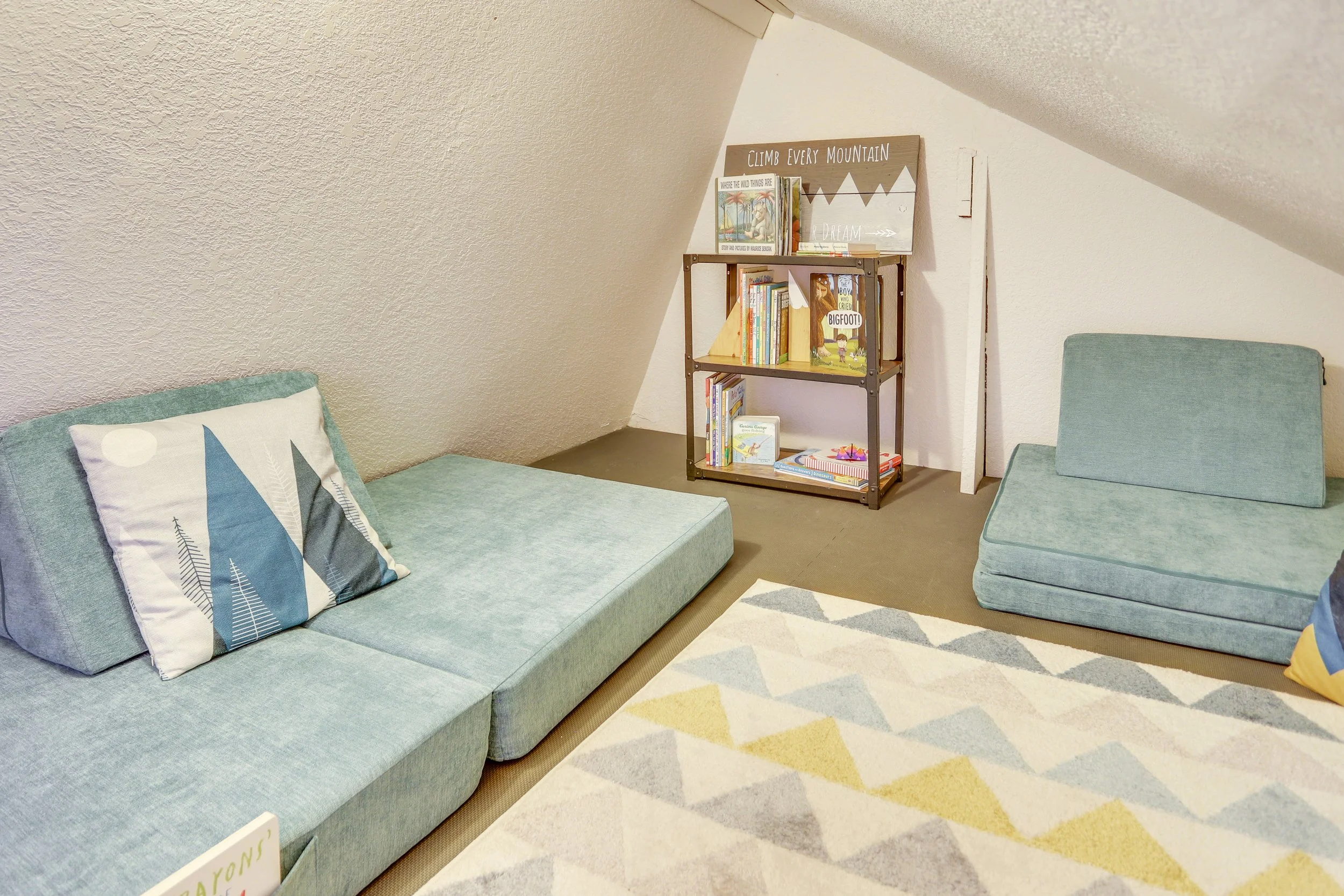 A loft is outfitted for fun with modular seating, books and toys to keep kids at play and their chaos out of the way.