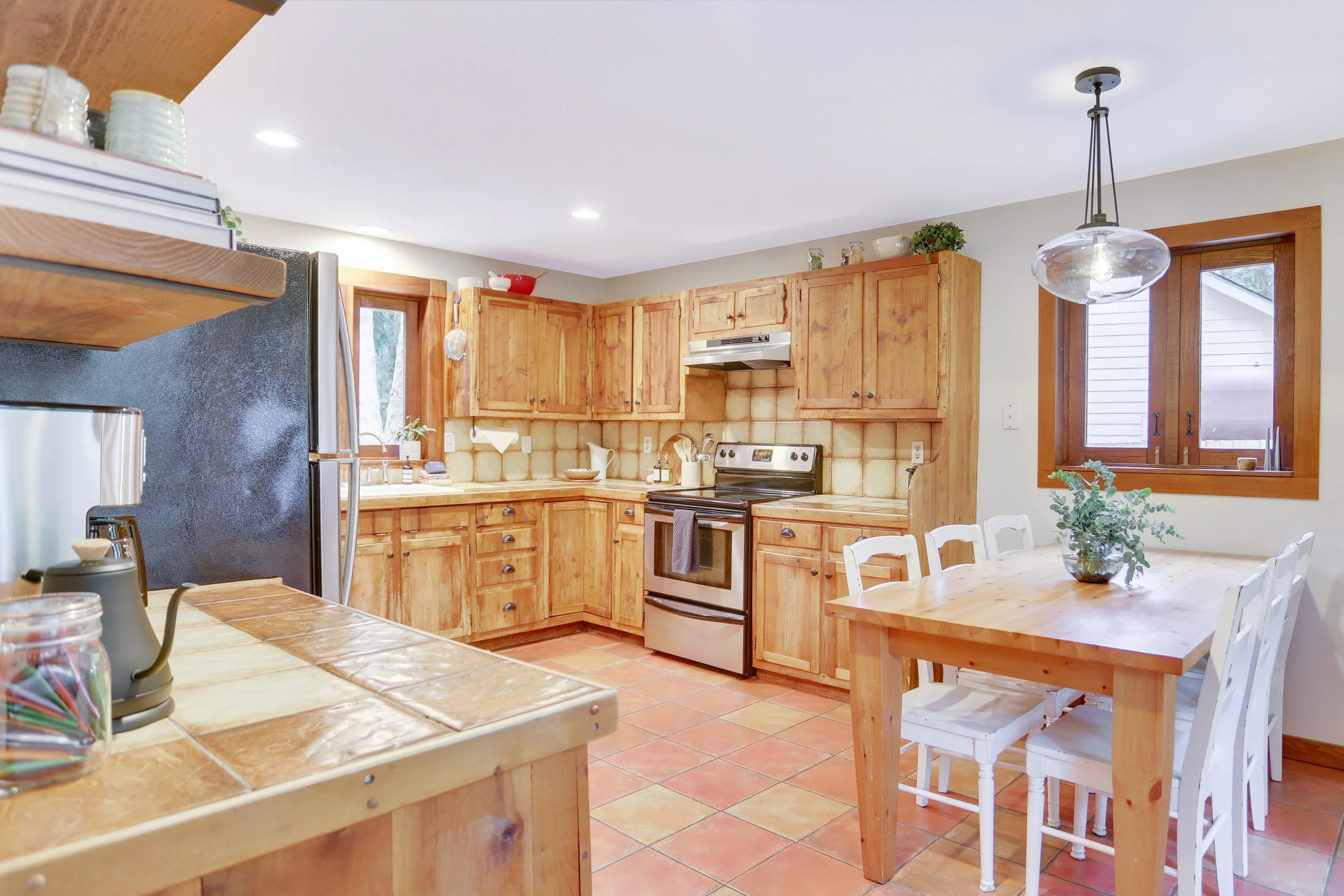 A clean, well-stocked kitchen complete with griddle, air fryer, coffee maker and quality dishes, serving and cookware. 