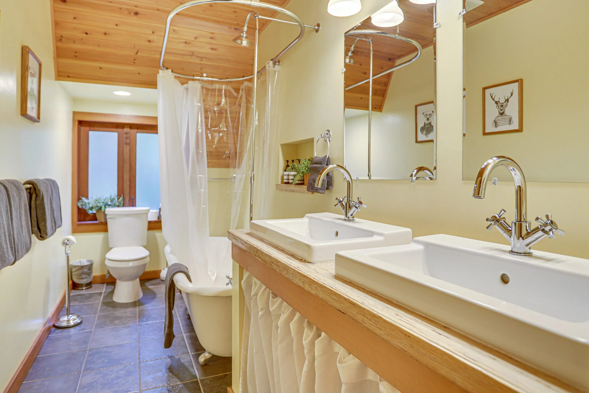 A sizable main bathroom offers a full-size, clawfoot tub and shower for soaking tired bodies, a double vanity sink and extra toiletries. 