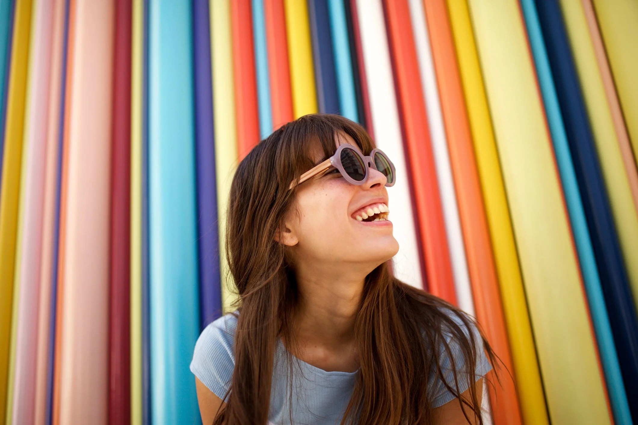 Woman smiling in front of colorful wall after panic attack therapy in Reston, VA