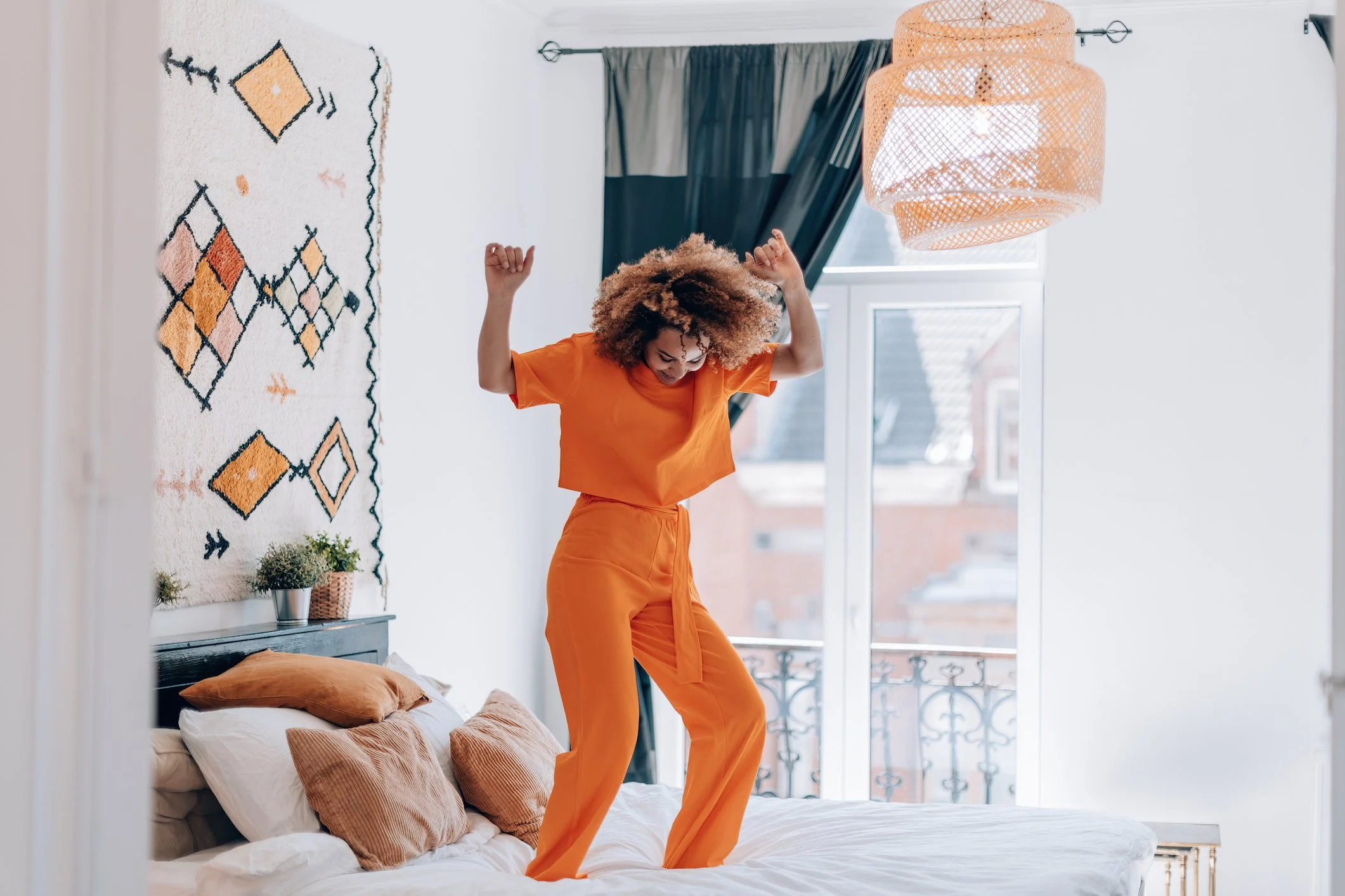Woman dancing on bed after virtual panic attack therapy session in Reston, VA