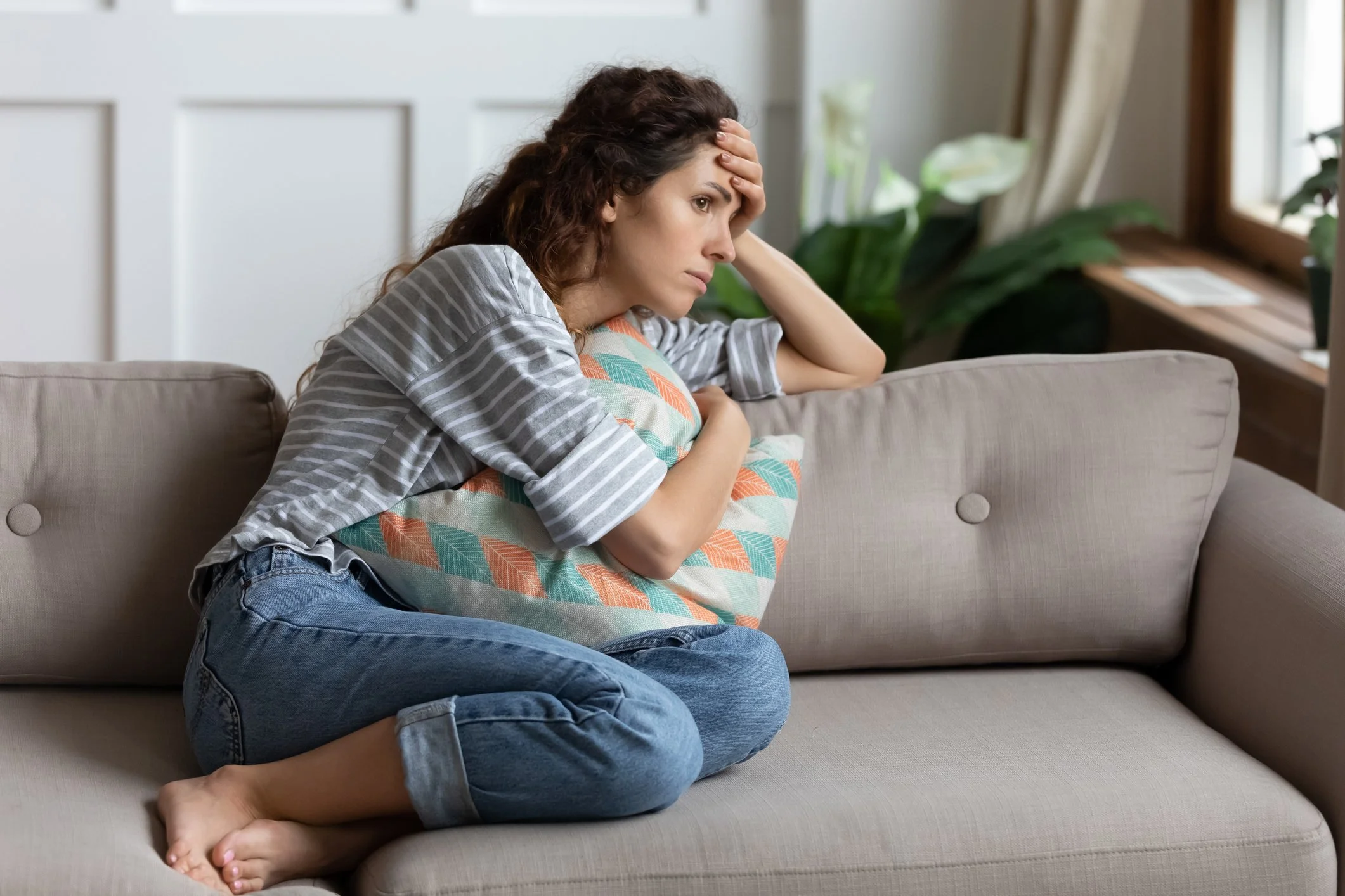 Woman sitting on couch in therapy session for panic attacks in Reston, VA.