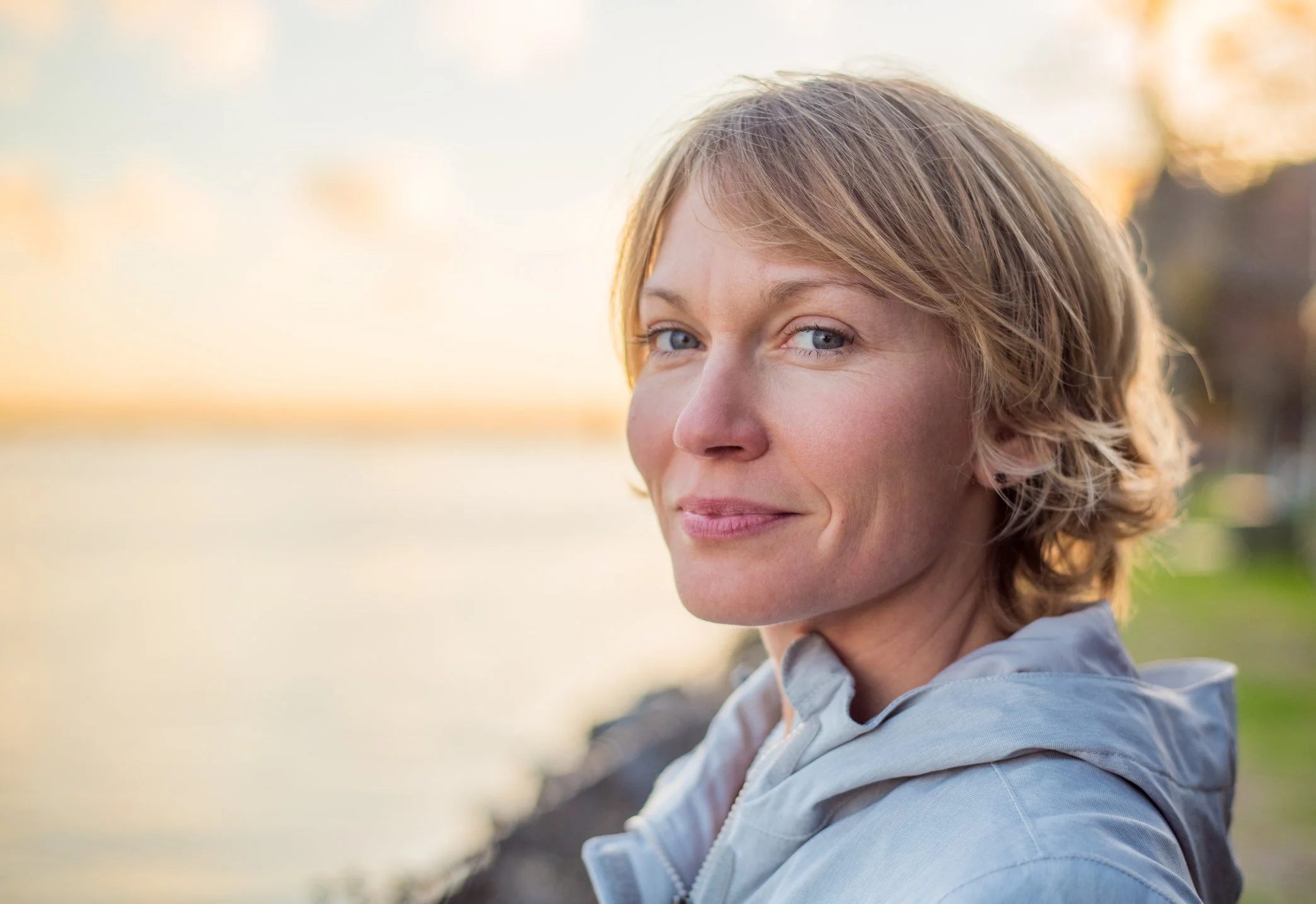 Woman at lake feeling good after therapy for panic attacks in Reston, VA