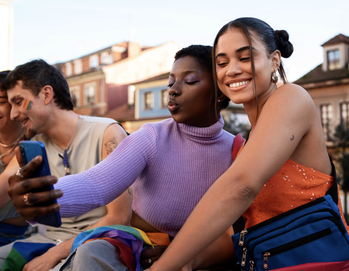 LGBTQ+ therapy centered on connection, identity affirmation, and emotional support, shown through a group of LGBTQ+ adults sharing a relaxed, supportive moment together.
