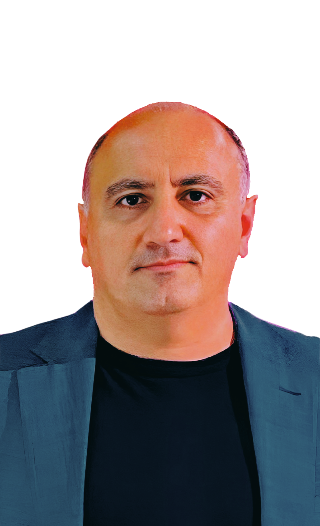 A man with short hair, wearing a blazer over a dark shirt, looking directly at the camera with a neutral expression.