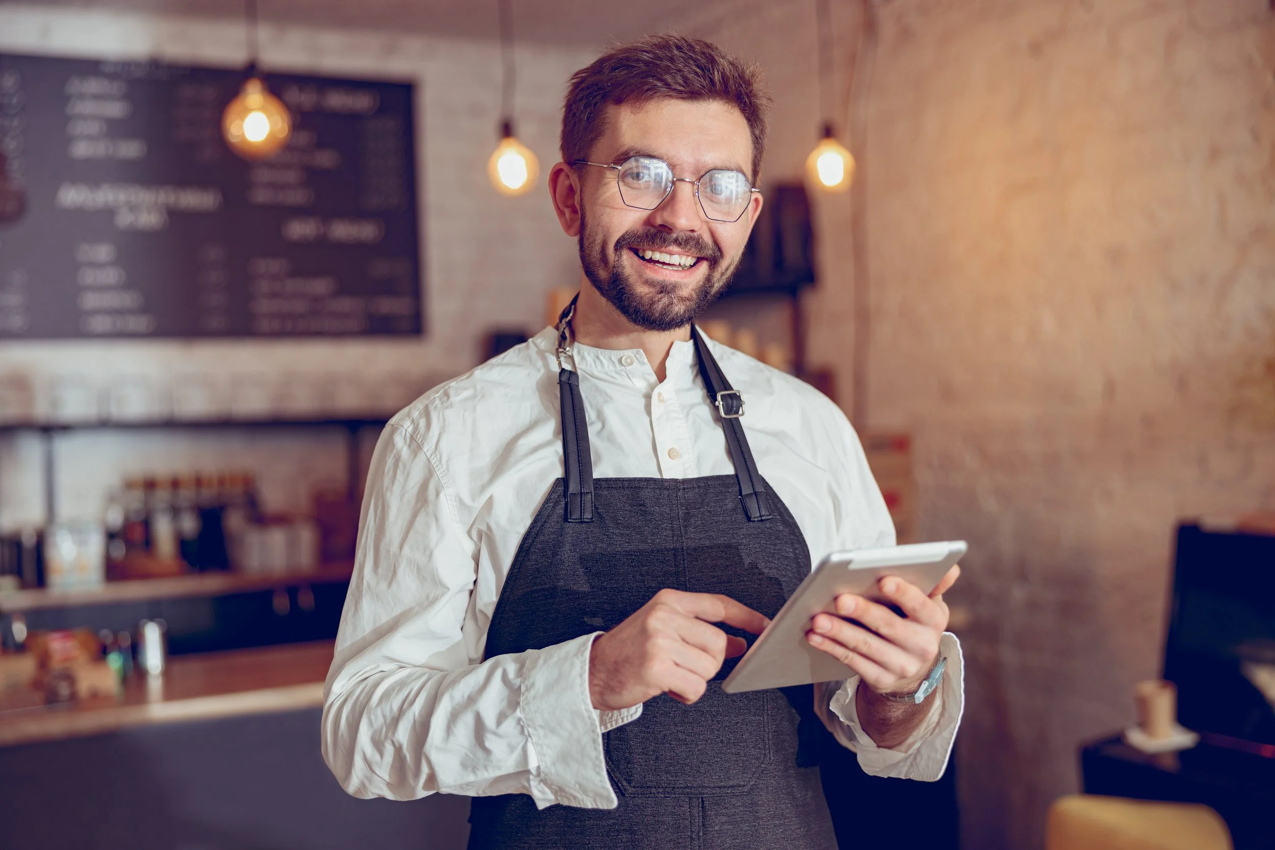 joyful-male-worker-using-tablet-computer-in-cafe-2023-11-27-05-04-03-utc.jpg
