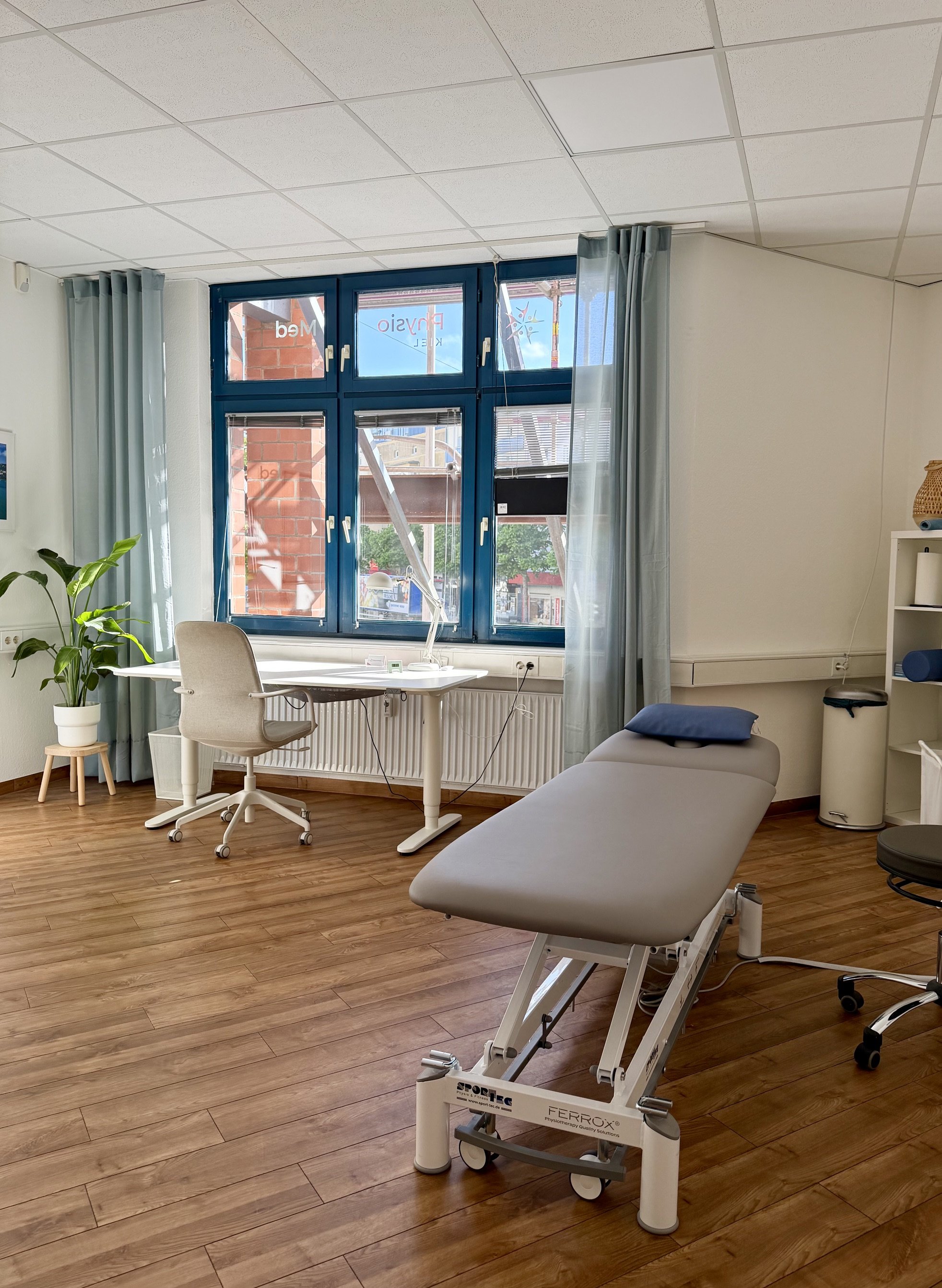 Behandlungsraum mit Therapieliege und Arbeitsplatz in der Praxis PhysioMed Kiel