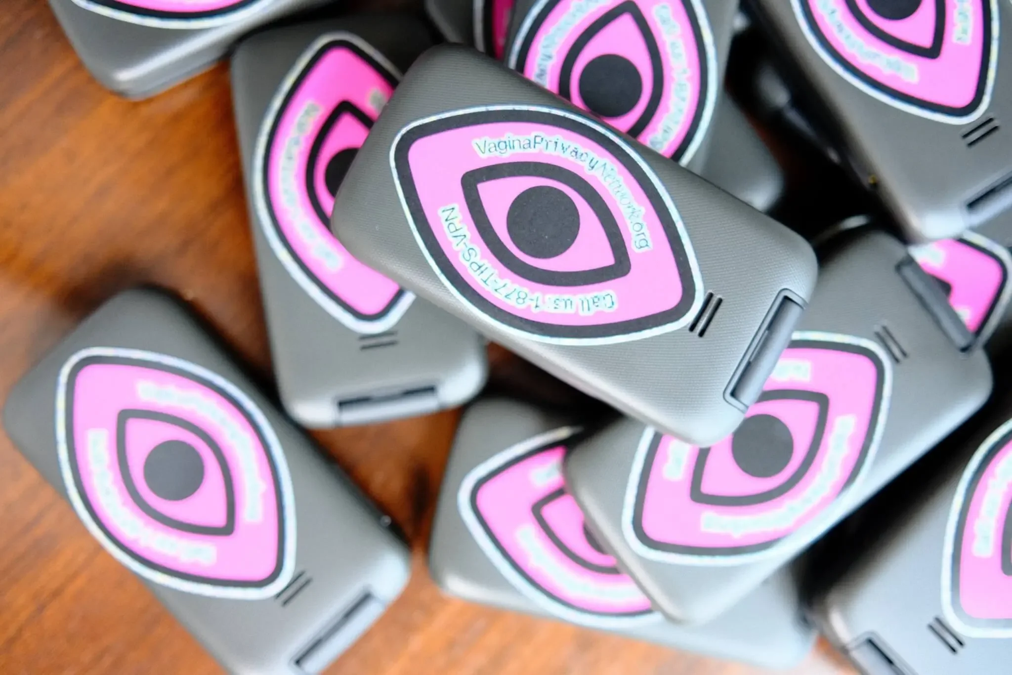 Burner cell phones featuring Vagina Privacy Network stickers that drive to a hotline featuring protective tips.