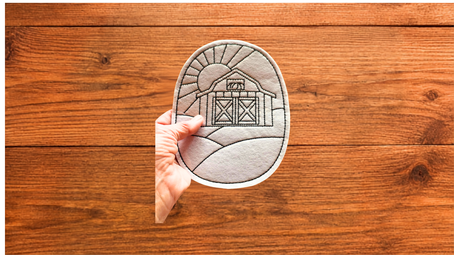 Hand holding Barn Landscape Coloring Cutie showing size and reusable coloring surface