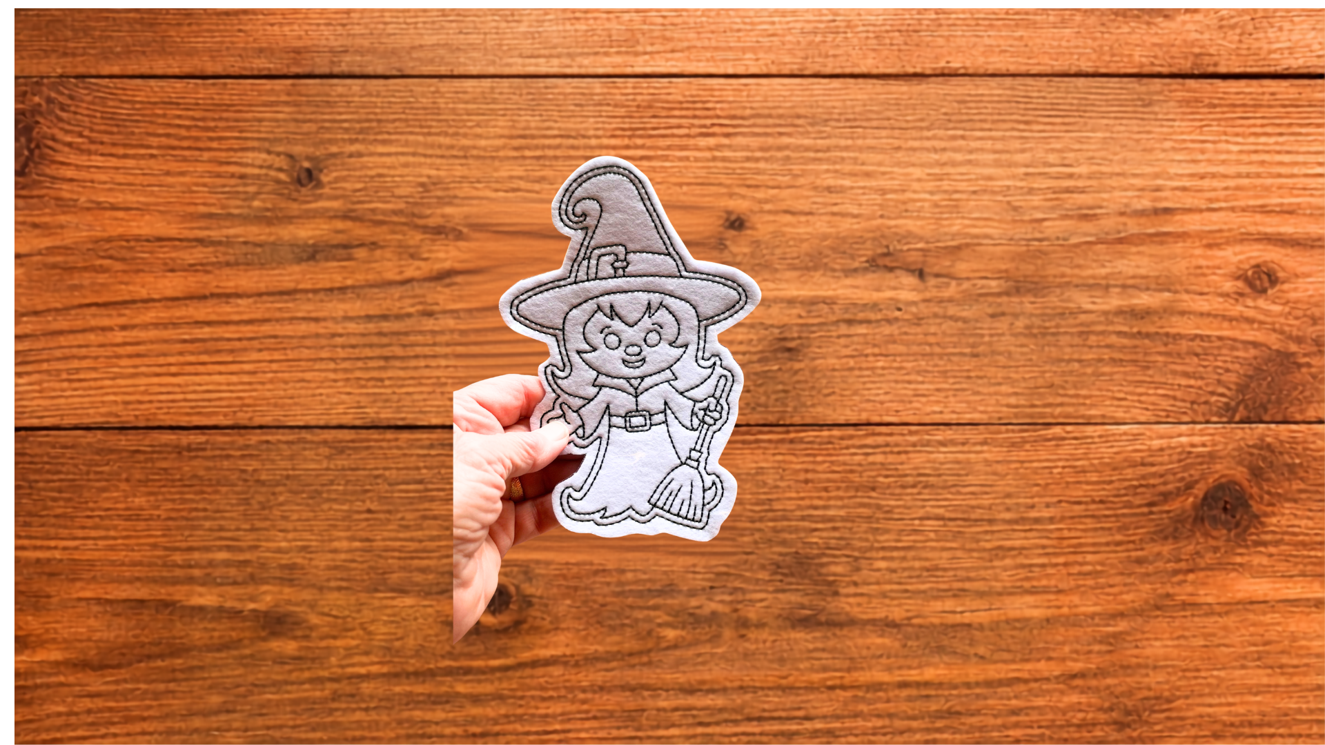 Hand holding reusable witch Coloring Cutie showing size and stitched details