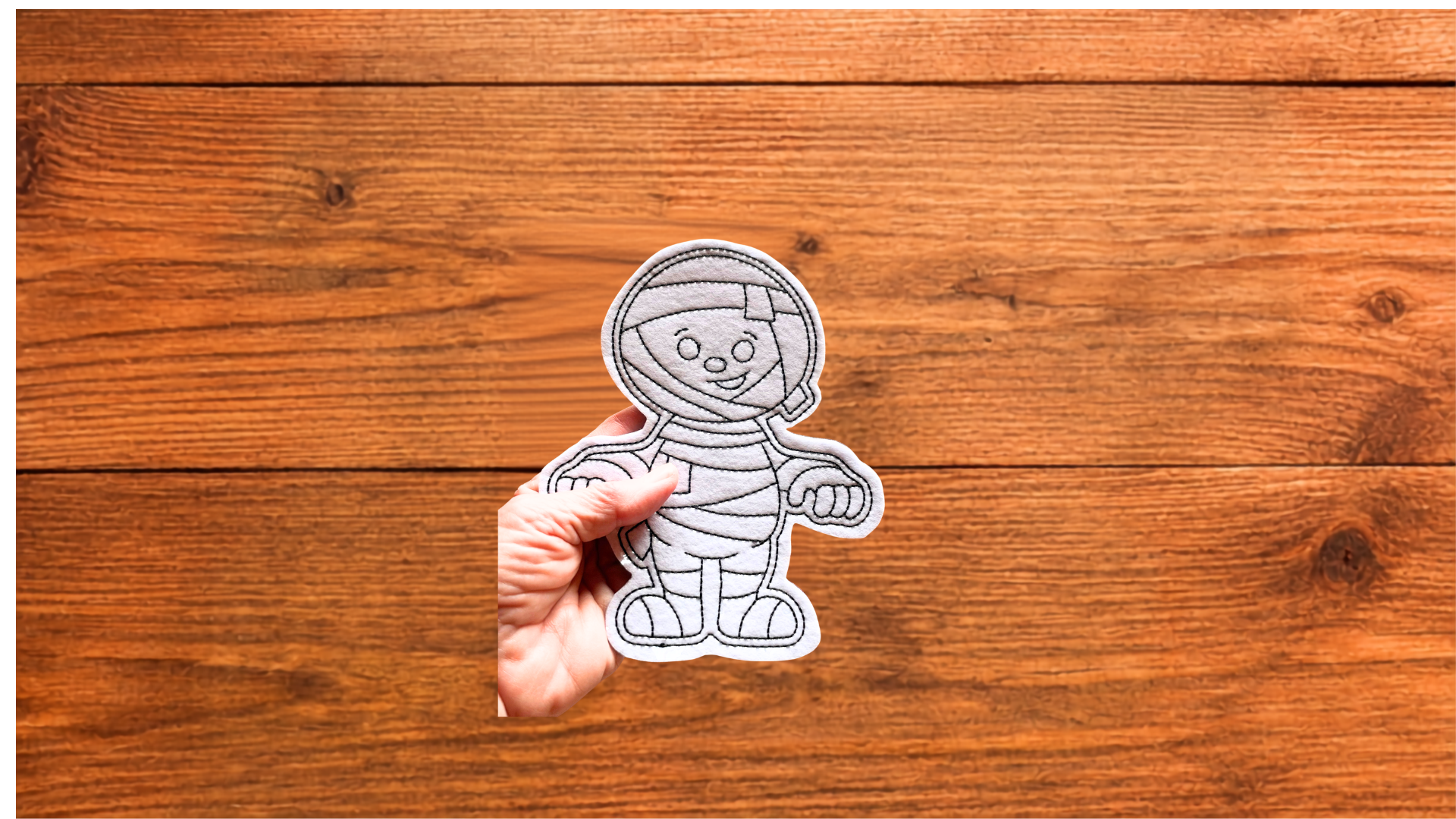 and holding reusable mummy Coloring Cutie showing size and stitched details