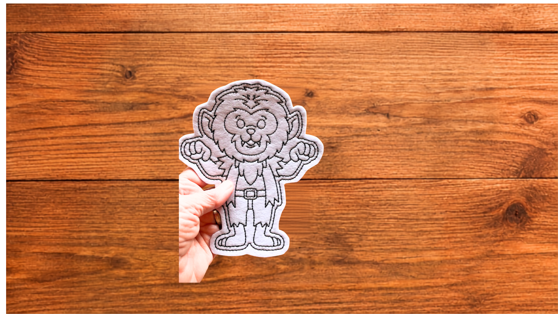 Hand holding reusable werewolf Coloring Cutie showing size and stitched details