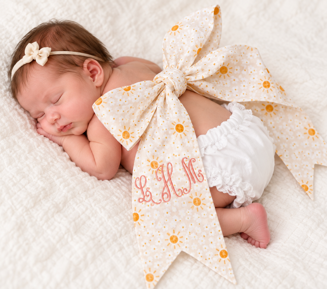 Newborn photo styled with a personalized monogrammed fabric bow as a baby photography prop. (Copy)