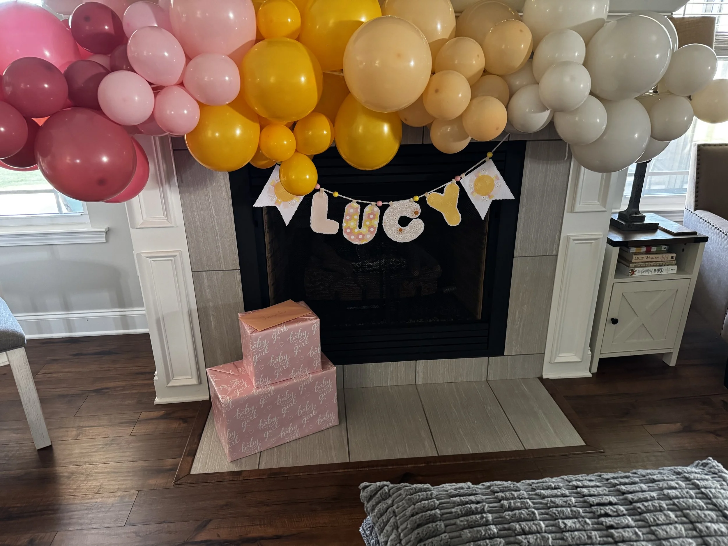 Personalized Lucy fabric name banner in pink and yellow cotton prints with cheerful sunshine accents.
