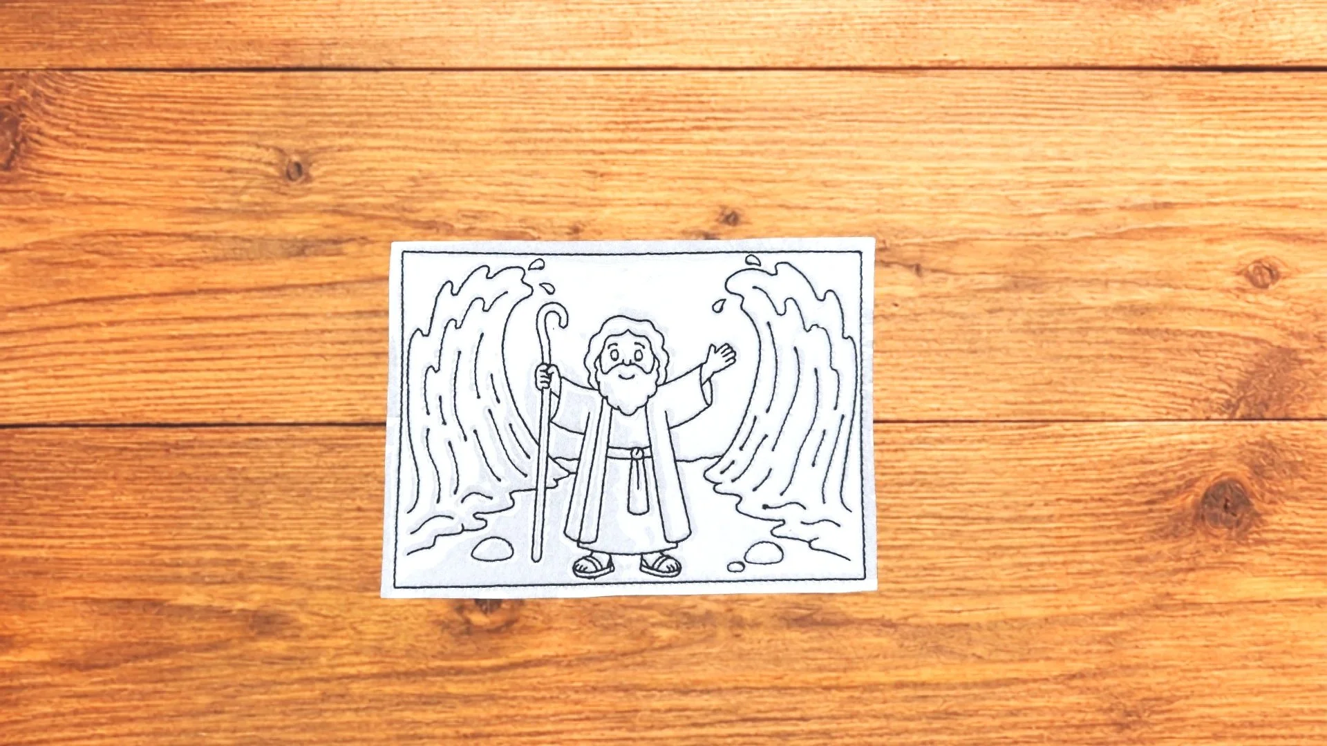 Parting of the Red Sea reusable Bible Story Coloring Cutie activity card on wooden background