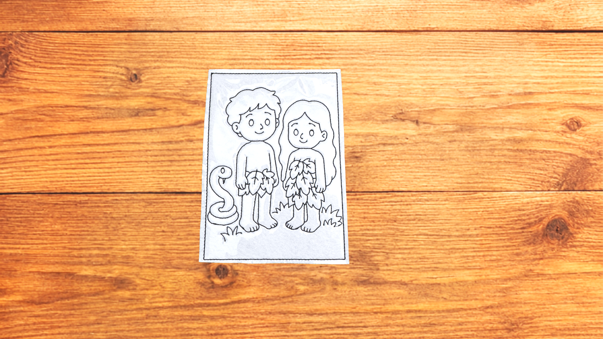 Adam & Eve reusable Bible Story Coloring Cutie activity card on wooden background