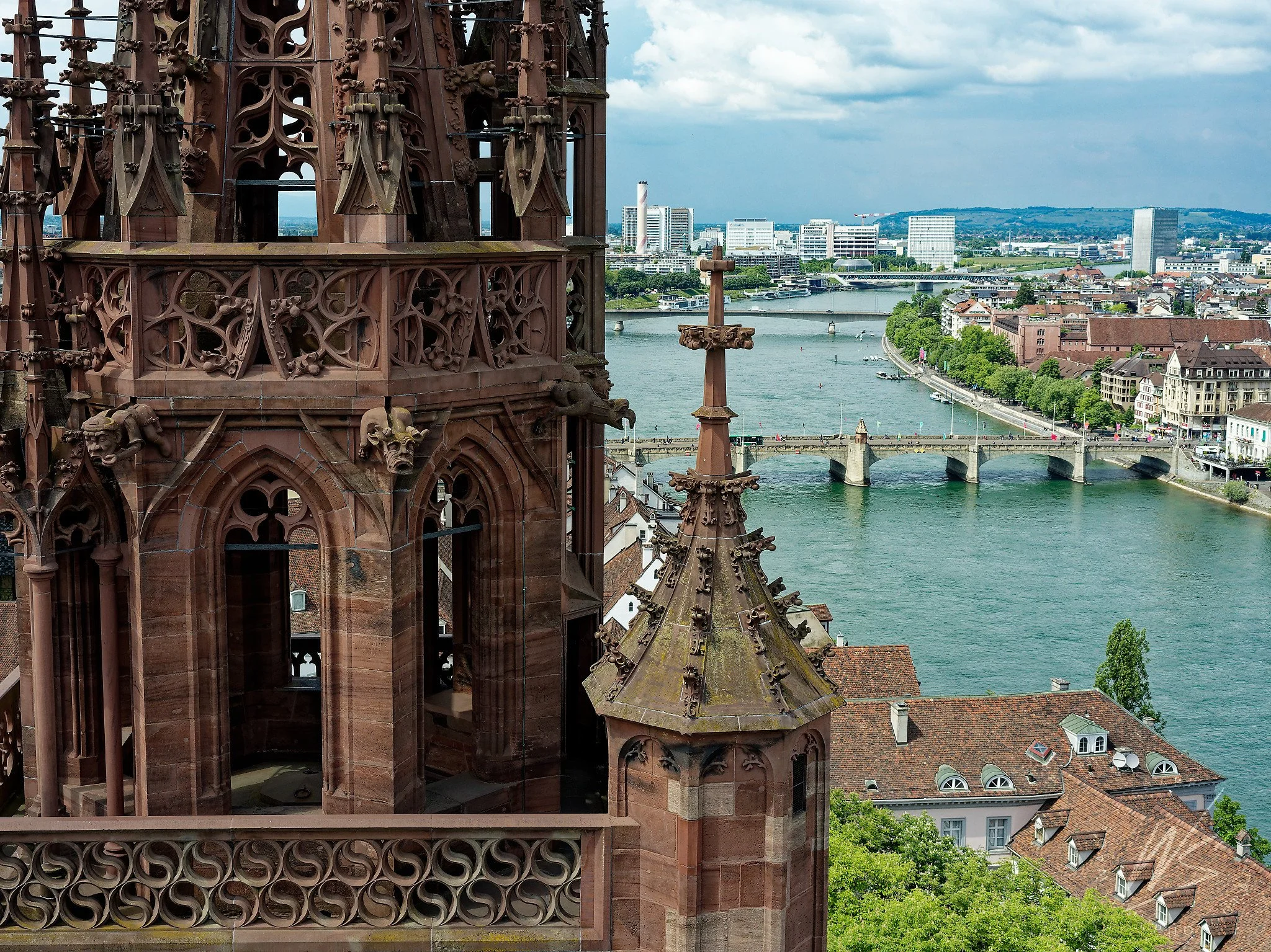 View from the tower of the Basler Münster (Basel Cathedral) over the Rhine River toward Kleinbasel, Basel, Switzerland. The Mittlere Brücke (Middle Bridge) and the Novartis campus towers are visible in the background. The cathedral's Gothic red sands