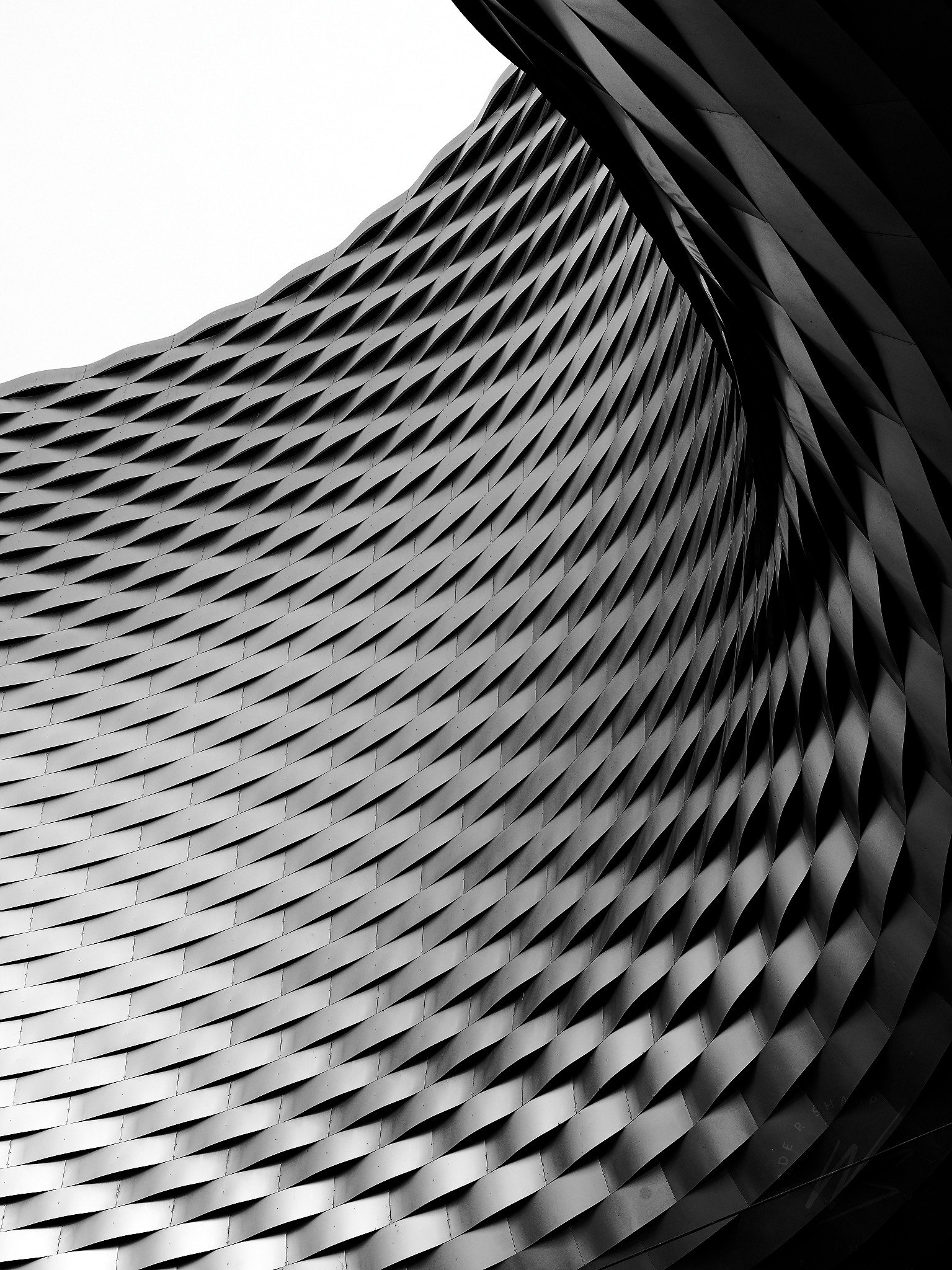 Messe Basel, Basel, Switzerland. The undulating aluminium diamond-panel facade of the Herzog & de Meuron-designed convention centre, opened 2013. Messe Basel served as the Eurovision Village and fan zone during the Eurovision Song Contest 2025. Black