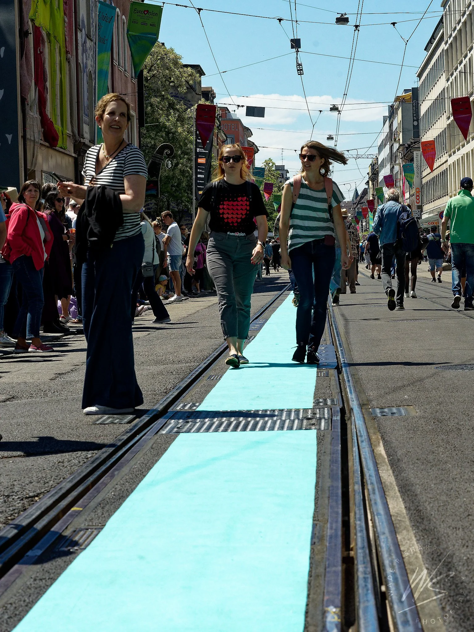 Basel city centre transformed for the Eurovision Song Contest 2025, Switzerland. Tram tracks painted turquoise — the contest's signature colour — line the pedestrianised Freie Strasse shopping street, decorated with Eurovision banners and colourful b