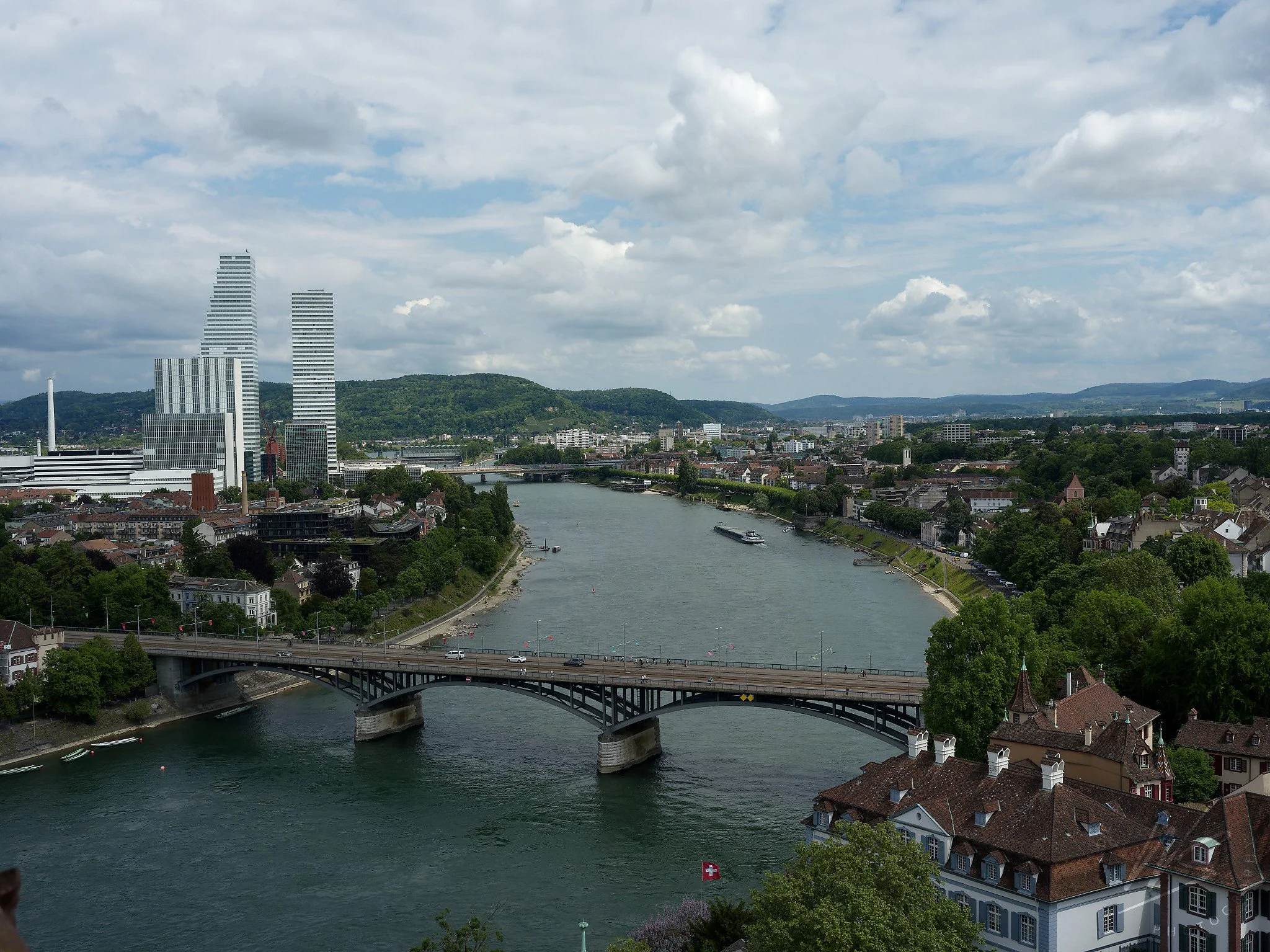 View from the tower of the Basler Münster (Basel Cathedral) looking upstream along the Rhine River, Basel, Switzerland. The Wettsteinbrücke crosses the foreground, while the two landmark Roche Towers — designed by Herzog & de Meuron on the F. Hoffman