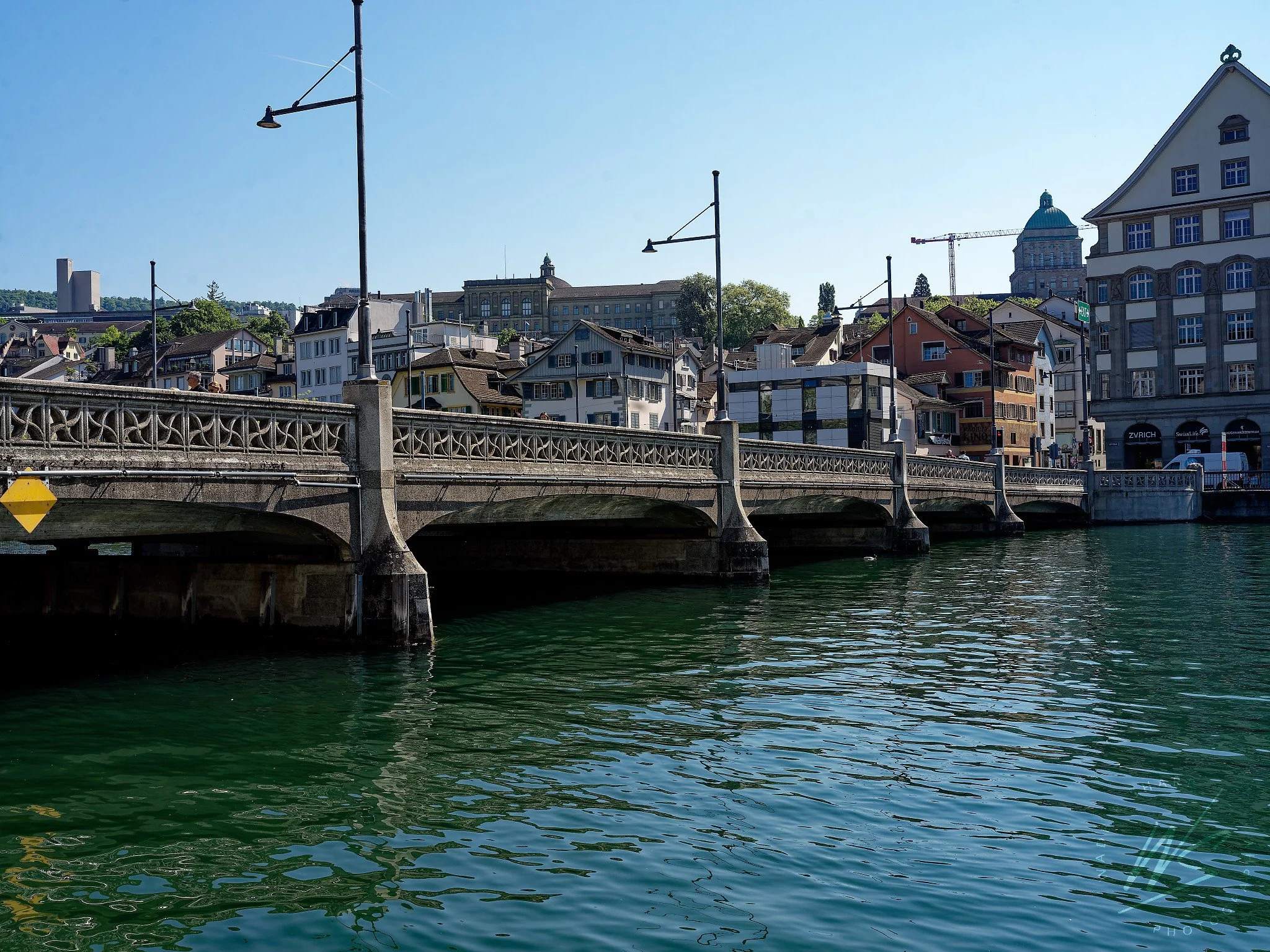 The Rathausbrücke (Town Hall Bridge) over the Limmat River, Zurich, Switzerland — also known colloquially as the Gmüesbrugg (Swiss German for "vegetable bridge"), recalling the medieval market once held on the bridge. The ornate cast iron railings da