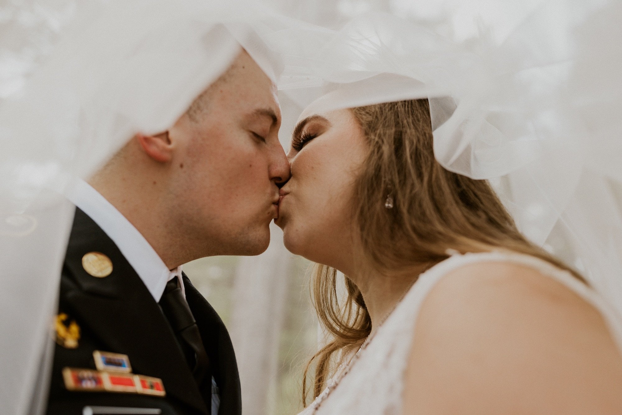 bride and groom kissing under veil.jpg