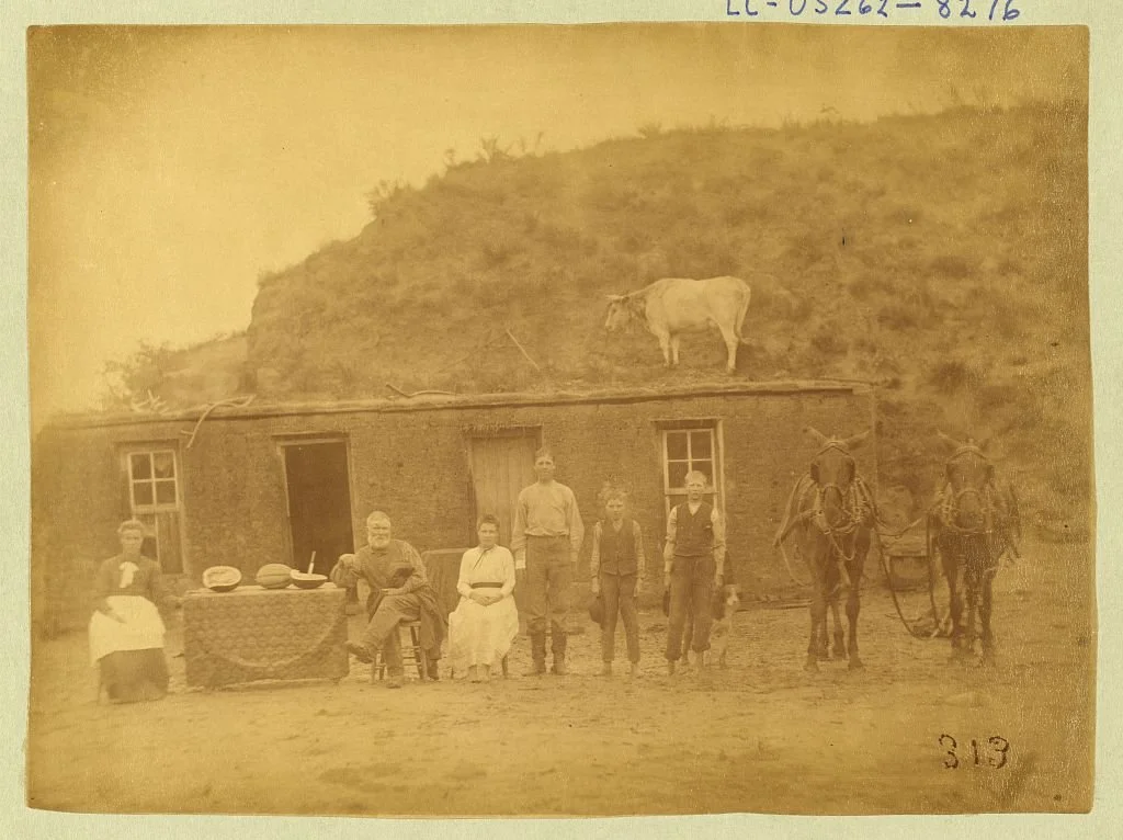Rawding family in front of their sod house with a cow on the roof, Custer County, Nebraska, 1886, photographed by Solomon D. Butcher