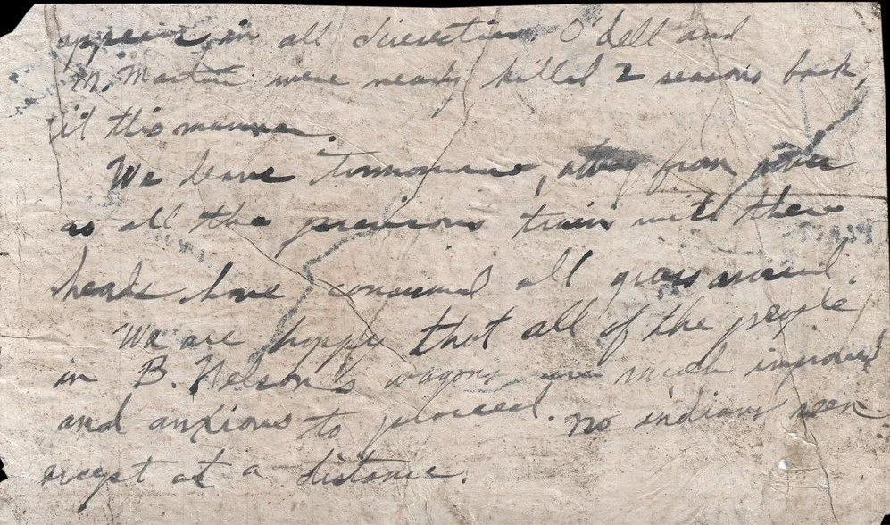 Back of the Oregon Trail emigrant map, circa 1851: a faded handwritten journal entry about men nearly killed two seasons back, grass consumed around camp, and the people in B. Nelson's wagons much improved.