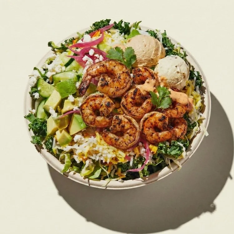 Burrito bowl mexicano con camarones rojos al achiote, frijoles negros, piña asada y arroz blanco.