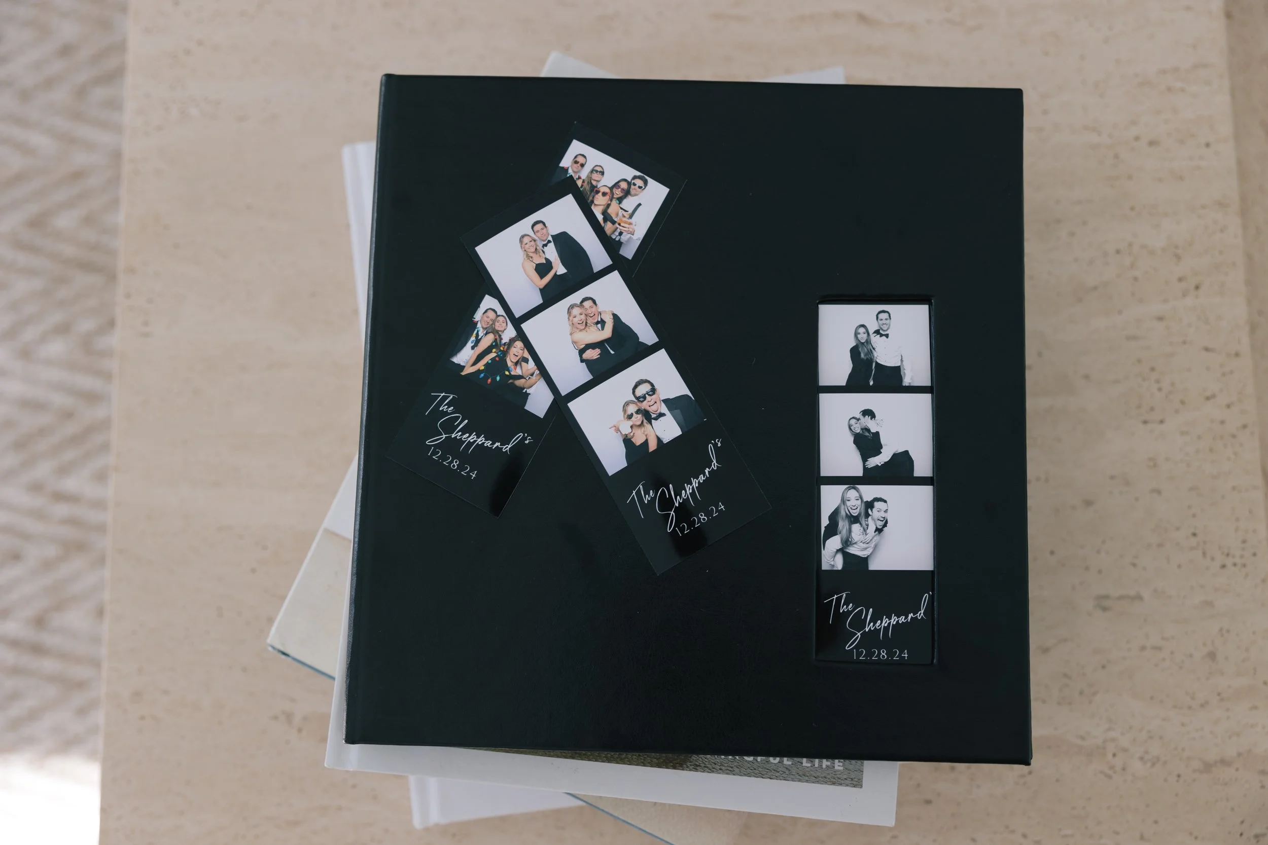 Two photo booth strips with black and white photos on a black box, each strip has four images of people posing at an event. The strips are labeled 'The Sheppard's' with the date '12.28.24'.