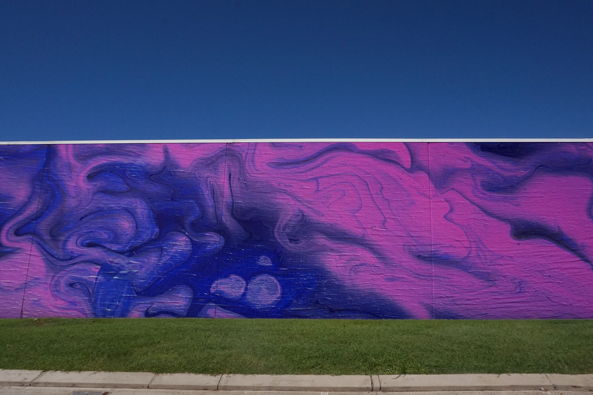 Outdoor white rendered wall mockup on urban building exterior for posters, murals, campaigns or large-scale artwork