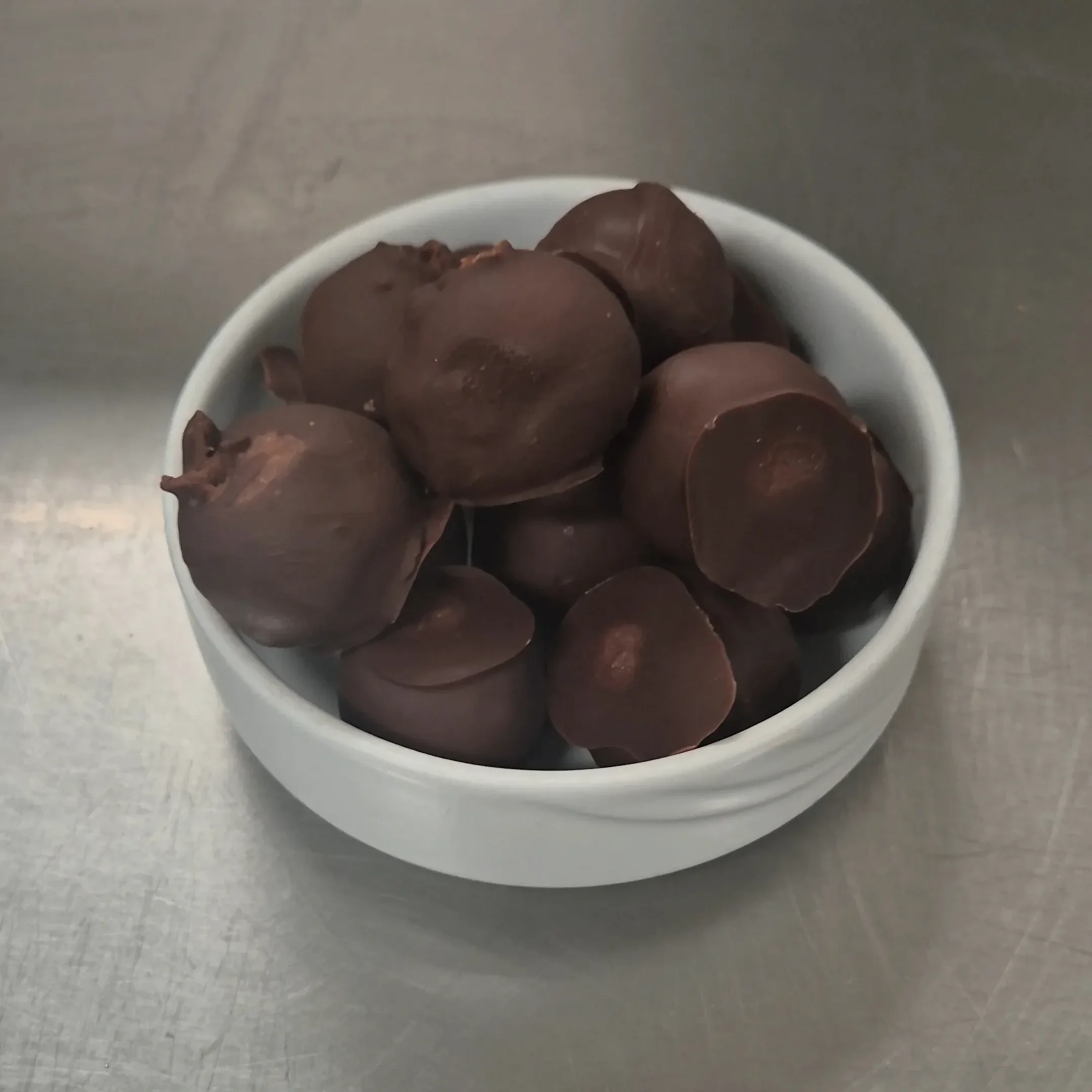 A bowl of easy chocolate chickpea truffles coated in dark chocolate and made with chickpeas and tahini.