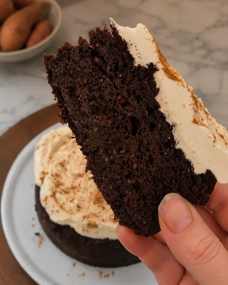 Close-up of a slice of chocolate tahini sweet potato cake showing its dense, fudgy texture.