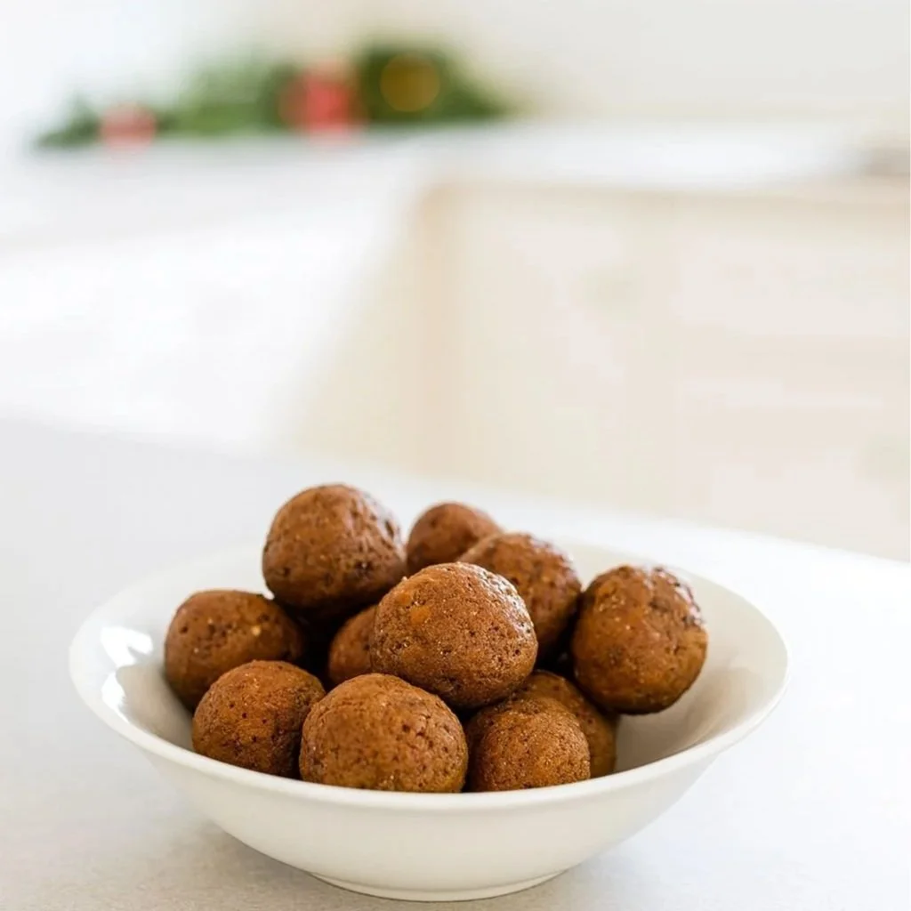 Bowl of gingerbread protein balls with dates, flax and pumpkin seeds - a no added sugar snack for women’s hormone health.