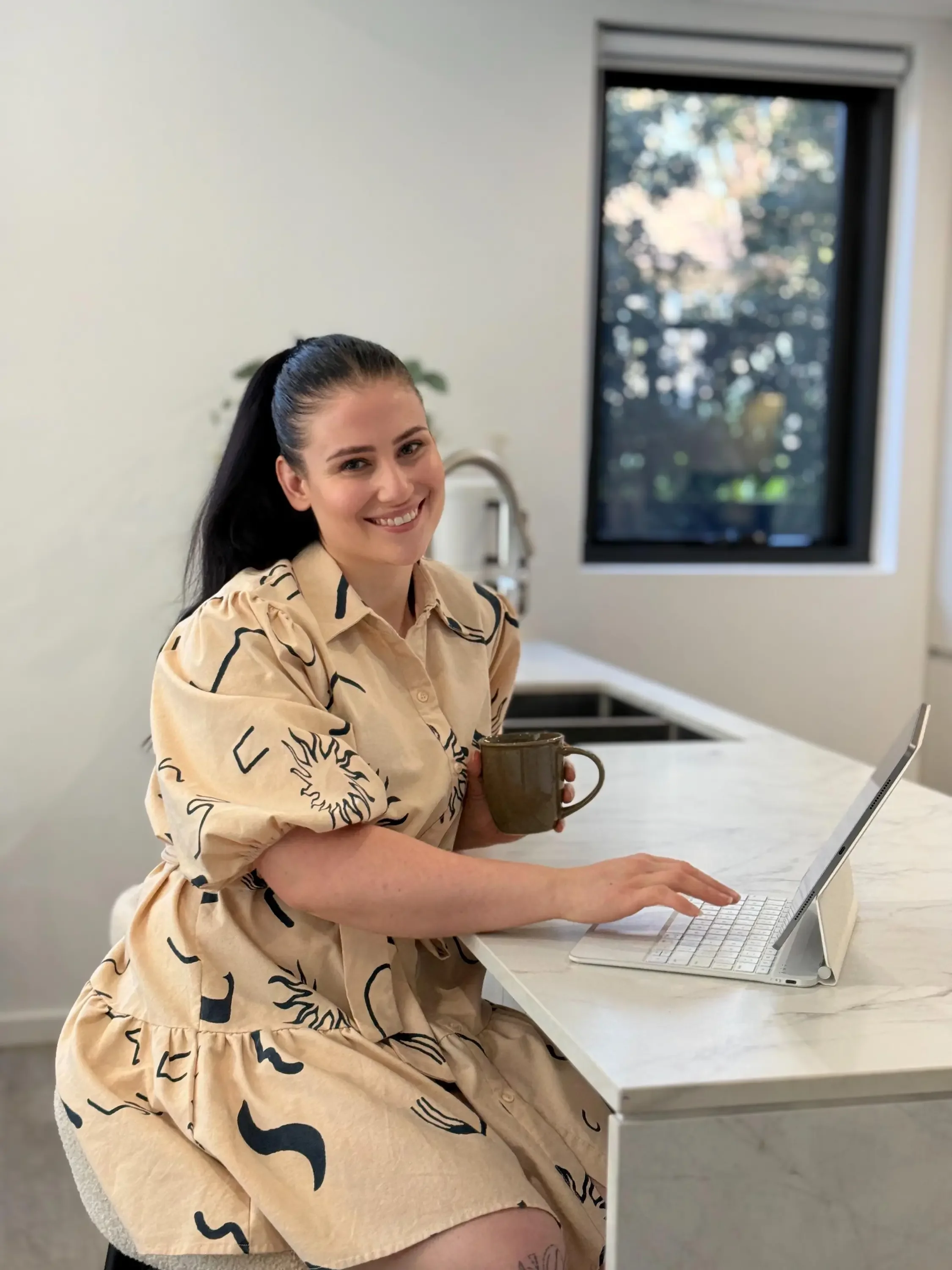 Courtney Heming, Feminalysis clinical nutritionist, seated beside her laptop