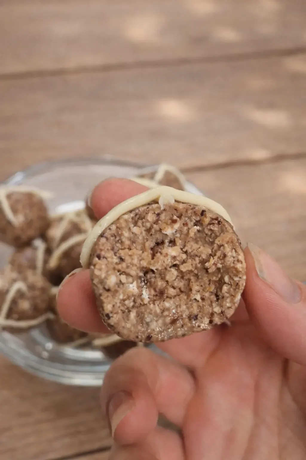 Close up of inside of hot cross bun protein ball showing soft raisin texture and spices