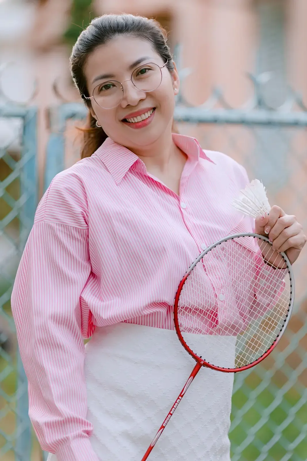 Happy Feminalysis client smiling outdoors after nutrition support improved her hormone health, bloating and menstrual cycles.
