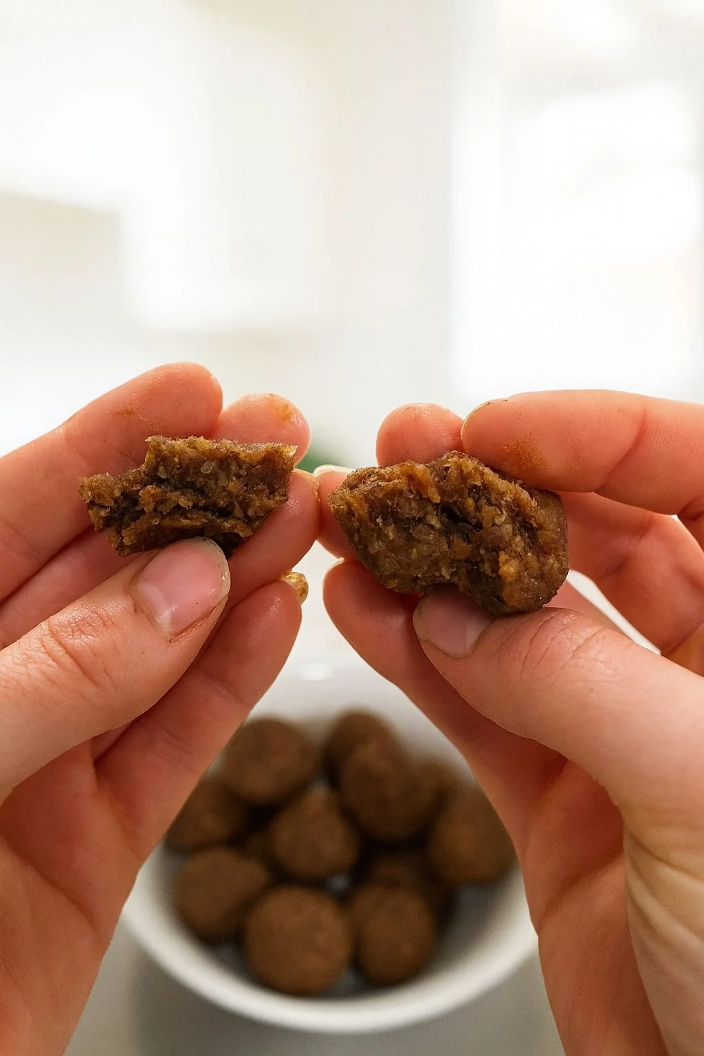 Close-up gingerbread protein ball split in half showing chewy date interior, with flax and pumpkin seeds - lunchbox friendly.