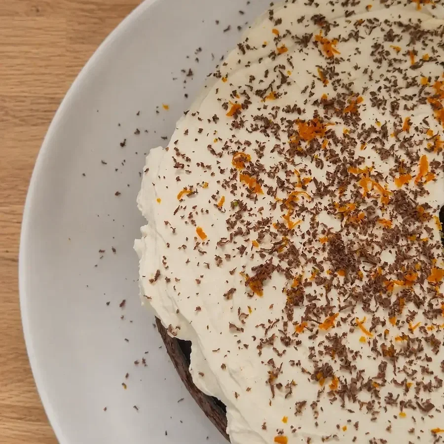 Close-up of a whole squash, dark chocolate and mandarin cake with a rich, moist texture and citrus zest.