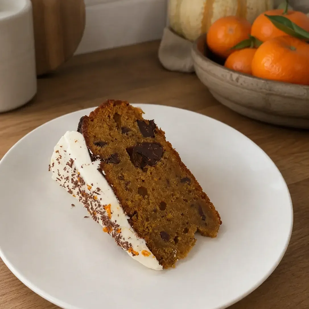 Single slice of squash, dark chocolate and mandarin cake showing chunks of melted dark chocolate.