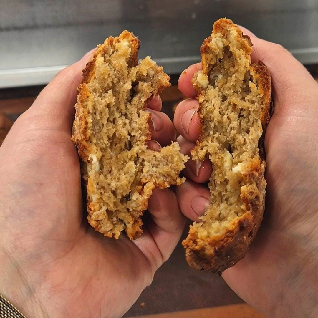 A soft tahini miso cookie being broken in half, revealing its gooey centre—packed with zinc, lignans, and isoflavones to support women’s hormonal health.