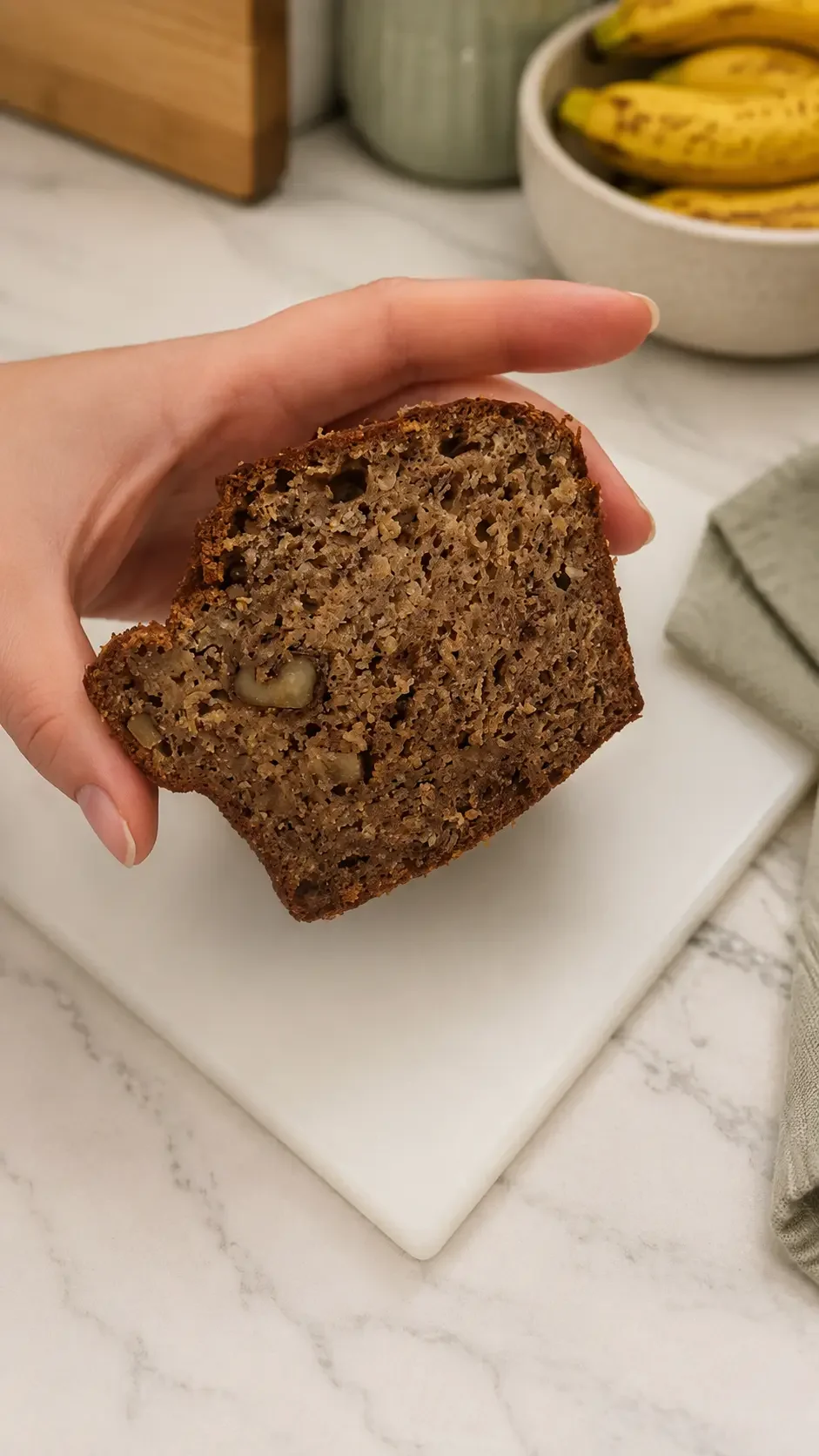 Close-up of moist healthy banana bread showing flax, chia, hemp seeds and chopped nuts throughout.